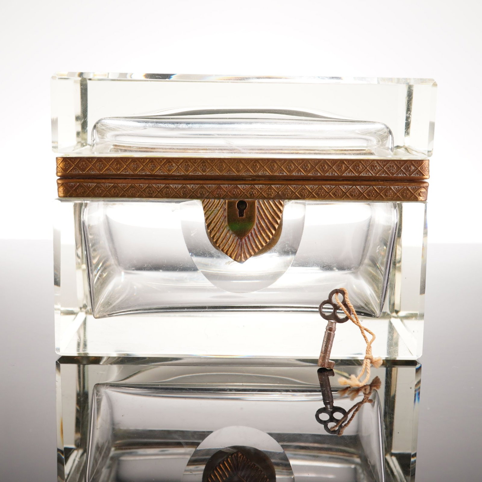 French Ormolu-Mounted Clear Crystal Jewelry Casket with Key: A substantial clear crystal jewelry casket or coffret, this heavy glass medium sized trinket box is likely of French origin from the late 19th to early 20th century. The piece is characterized by