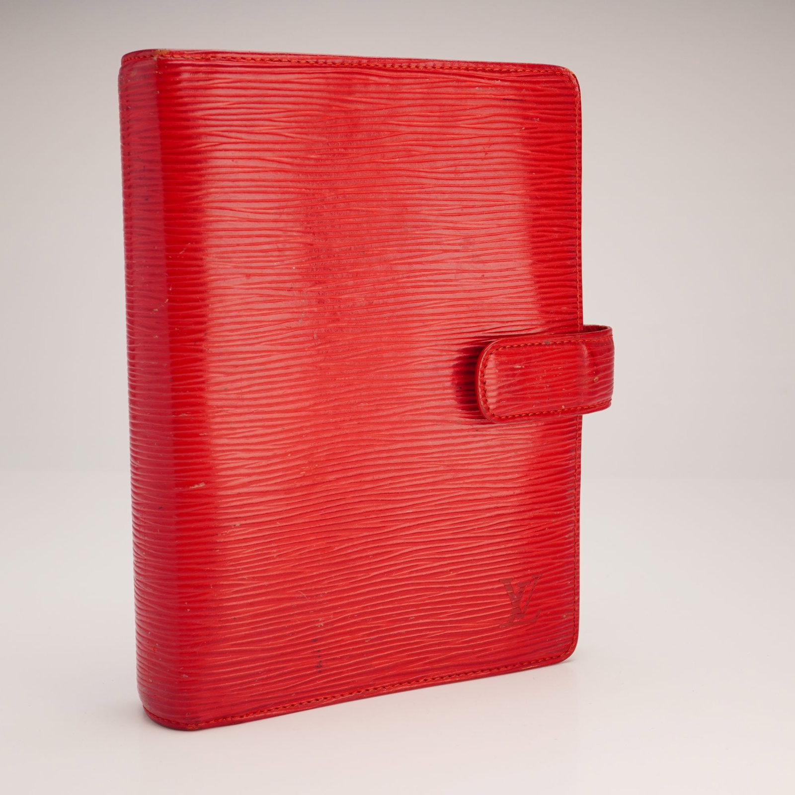 Louis Vuitton Red Epi Leather Agenda MM Notebook Cover: This Louis Vuitton Agenda MM (Medium) notebook cover is crafted from Castillian Red Epi leather, featuring a signature horizontal ridged texture and tonal stitching. The exterior is designed with a wr