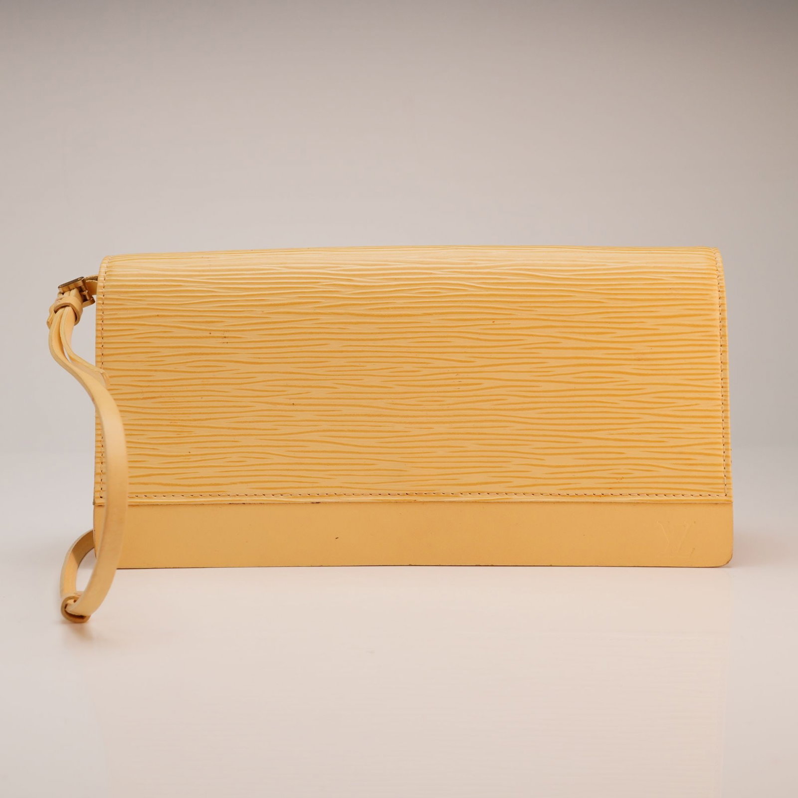 Louis Vuitton Honfleur Vanilla Epi Leather Clutch Shoulder Bag: This Louis Vuitton Honfleur bag is constructed from the brand signature textured Epi leather in a vanilla yellow shade. The rectangular design features a front flap with a snap button closure and a