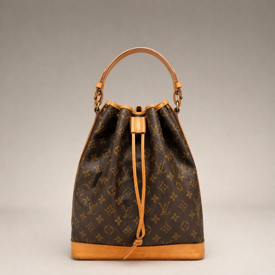 Vintage Louis Vuitton Noe Bucket Bag: This is a vintage Louis Vuitton Noe bucket bag, a style originally created in 1932. The bag features a signature monogram coated canvas body with natural Vachetta leather trim and a reinforced leather