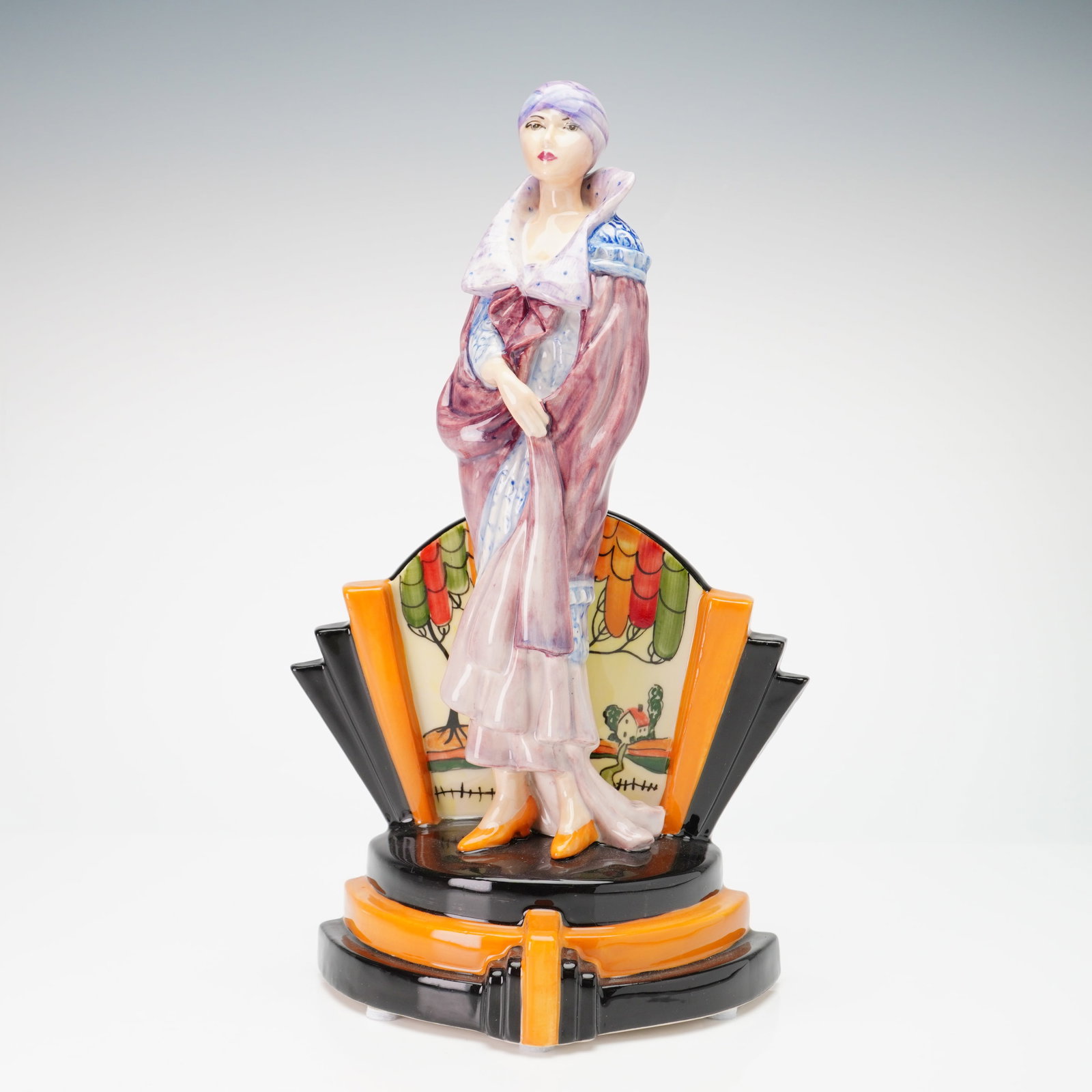 Kevin Francis Peggy Davies by Victoria Bourne Artist Original Proof Figurine: The art deco figure depicts a woman in early 20th-century fashion, wearing a purple turban, a draped purple and maroon wrap, and a blue and white patterned dress with orange shoes. The figure stands b
