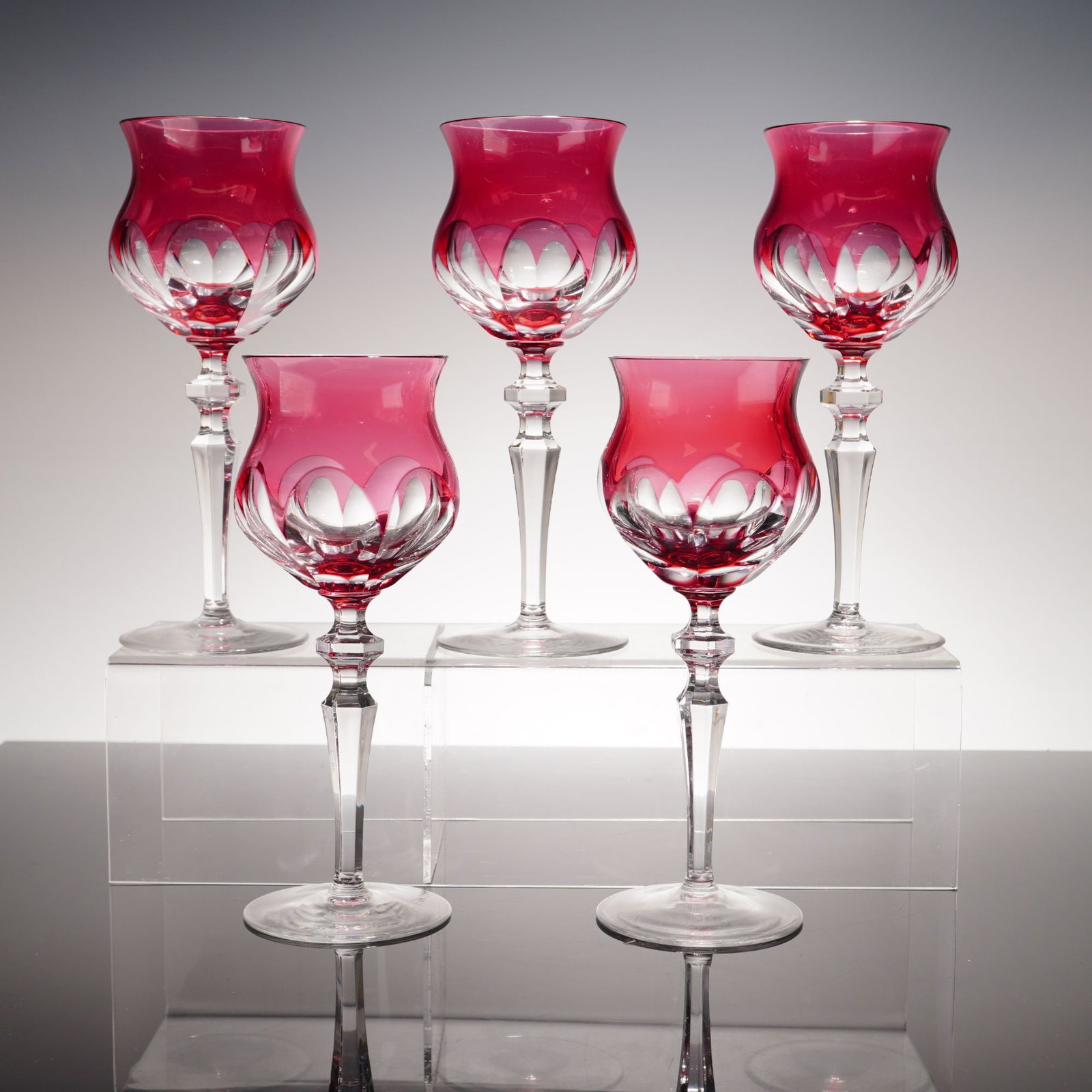 5pc Nachtmann Ruby Cased Cut to Clear Crystal Wine Glasses: A set of five wine glasses crafted from cased lead crystal. Each glass features a vibrant ruby red or cranberry colored layer of glass over a clear crystal base, with the outer colored layer cut away 