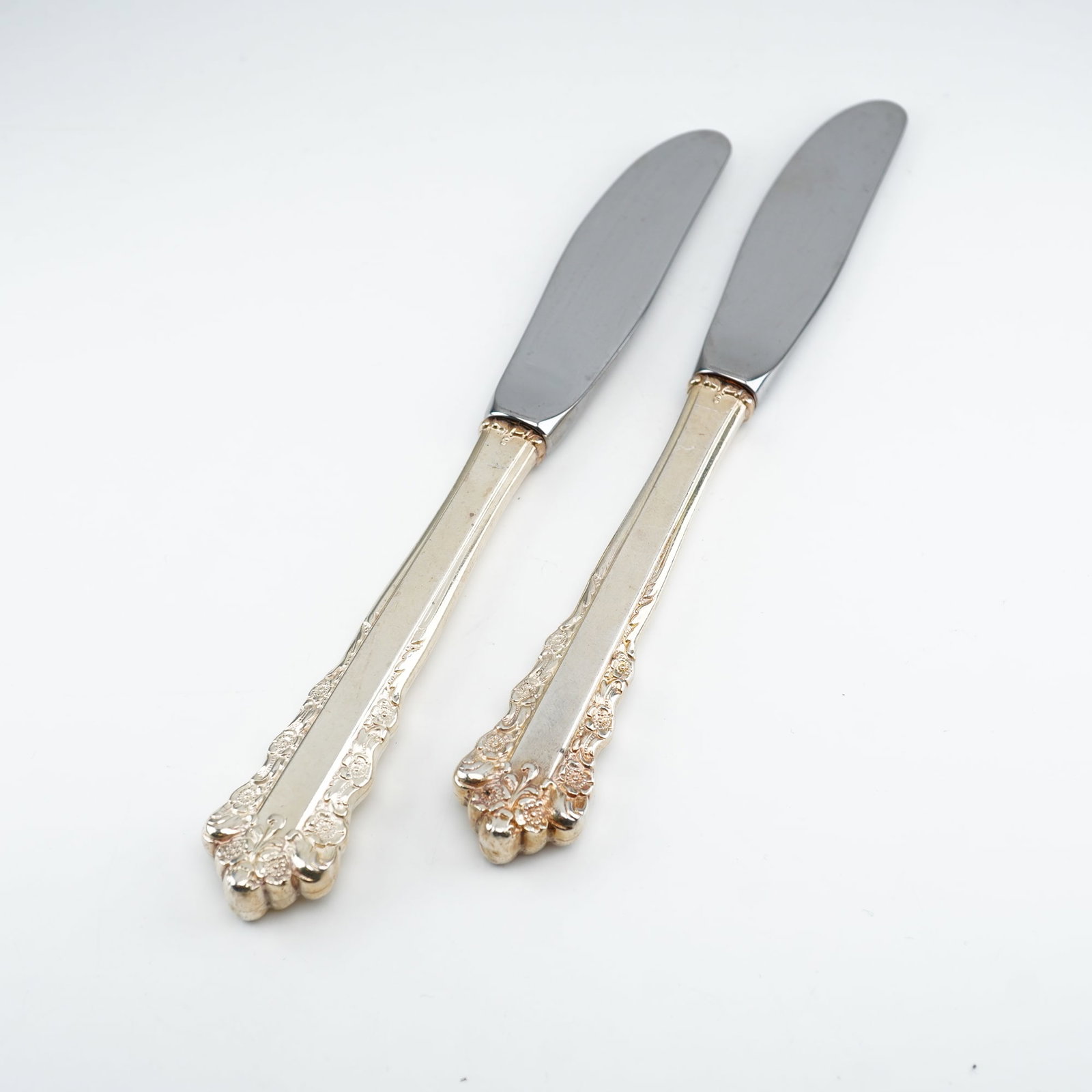 2pc Lunt Sterling Silver and Stainless Steel Butter Spreaders, Belle Meade: Made by Lunt Silversmiths from 1967"1997, each piece displays an elaborate Rococo-inspired design with raised floral clusters and flowing scrollwork along the handle borders and terminals. Floral orna