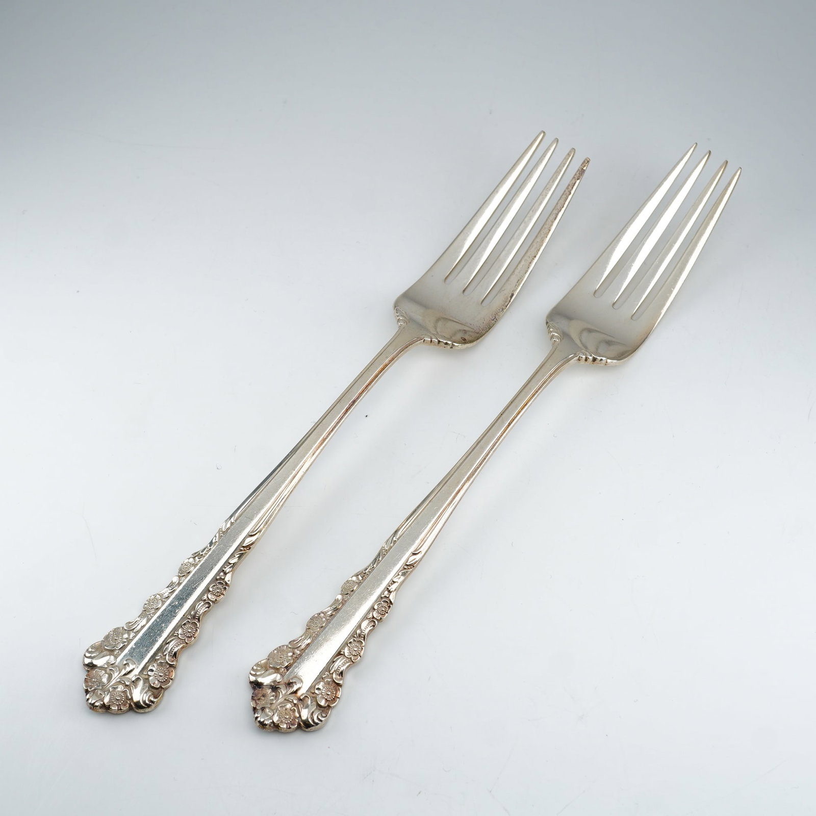 2pc Lunt Sterling Silver Dinner Forks, Belle Meade: A set of two sterling silver dinner forks in the Belle Meade pattern by Lunt Silversmiths. The pattern features an elaborate floral and scrollwork design with Rococo influence, including raised floral