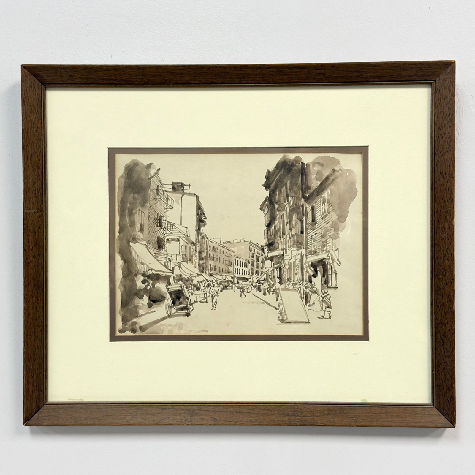 Framed Urban Street Scene Ink and Wash Drawing on Paper: This monochromatic work on paper is executed in ink and wash, depicting a busy urban street scene. The composition features a variety of figures, horse-drawn carts, and detailed architectural