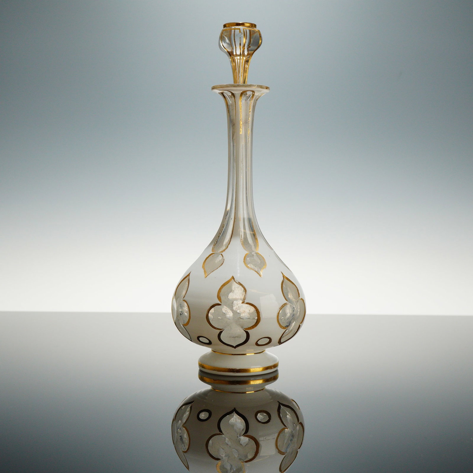 Bohemian Style White Opaline Gilded Glass Perfume Bottle with Stopper: This mid-to-late 19th-century perfume bottle is composed of white opaline glass cased over clear glass. The pear-shaped body rests on a circular pedestal foot and transitions into a long, slender neck