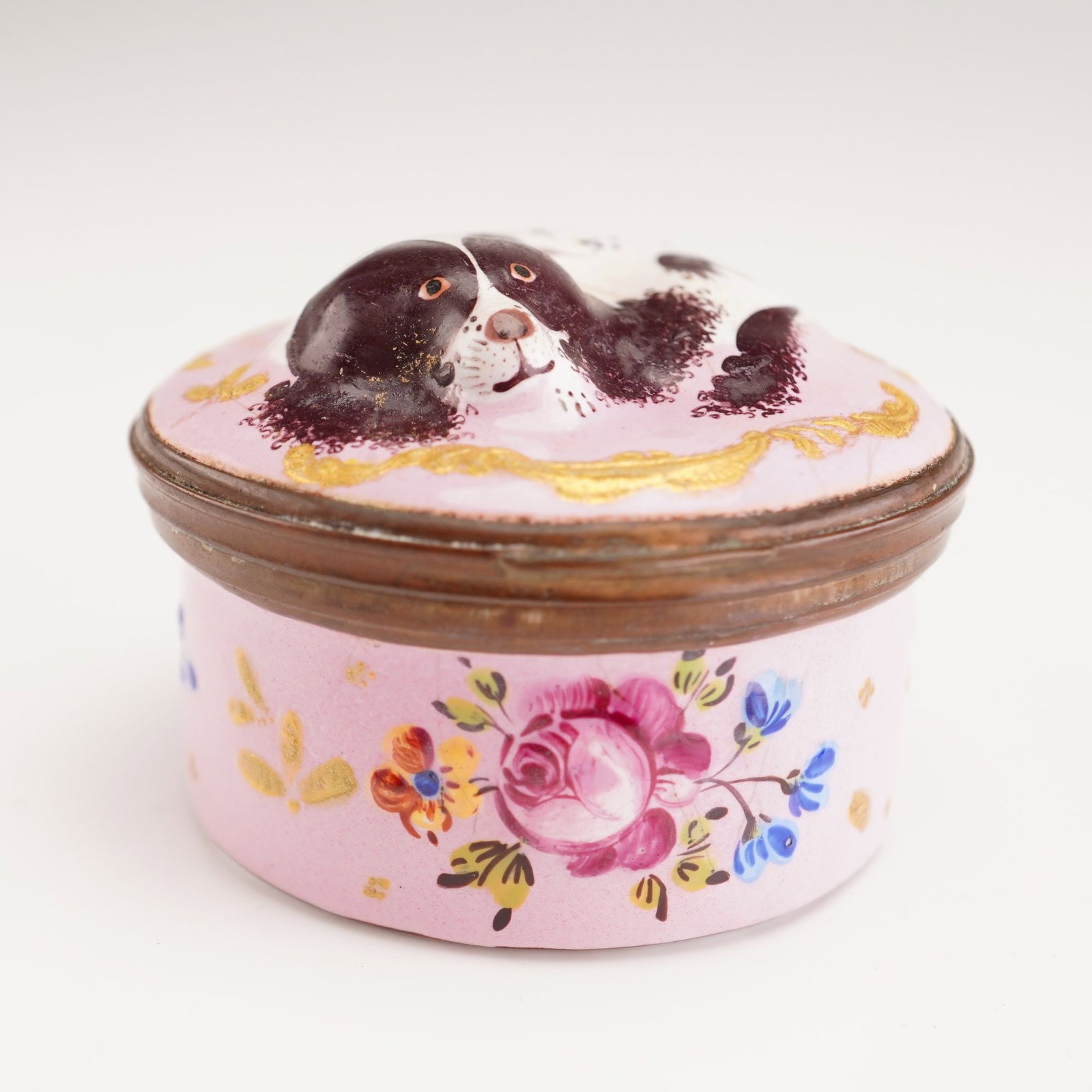 Antique English Enamel Bonbonniere, King Charles Spaniel: This small, circular hand painted porcelain treasure box is designed in the tradition of 18th-century English enamel patch boxes. The hinged lid features a relief-molded and hand-painted head of a Kin