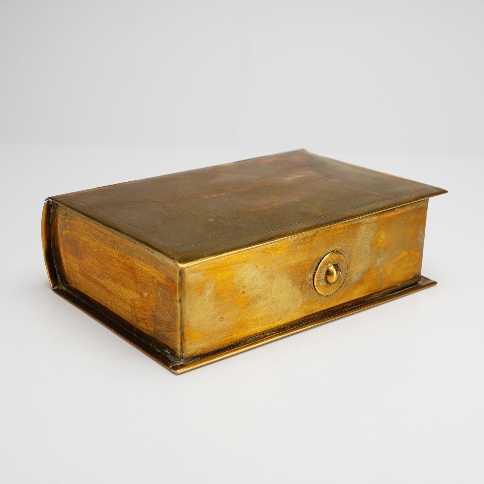 Brass Book-Form Box with Internal Dividers: This brass box is designed in the shape of a bound book and features three internal dividers. The piece is constructed from brass sheet with soldered seams and a curved spine. The spine is detailed wi