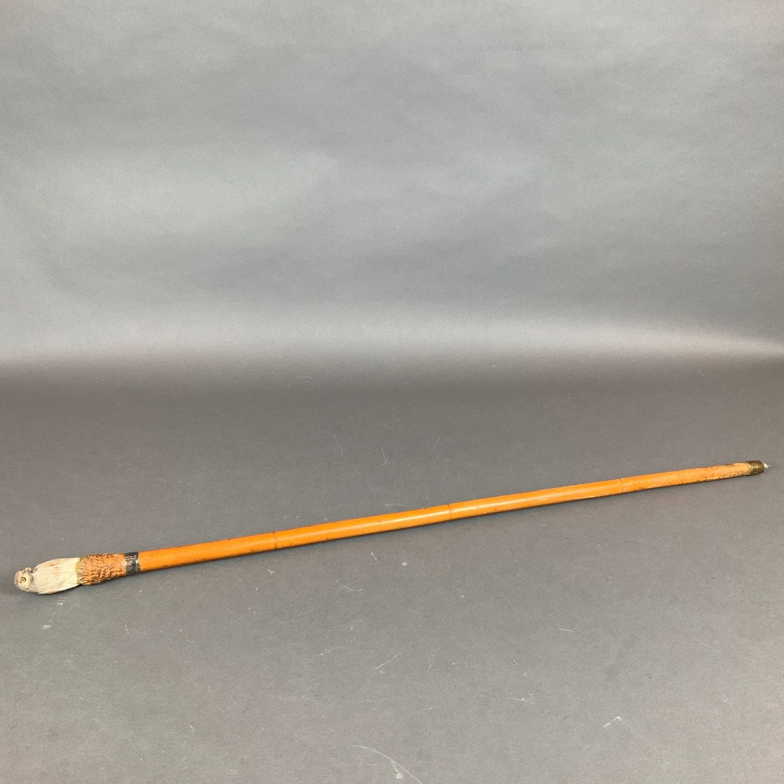Carved Bird Wooden Walking Cane with Sterling Silver Collar: This antique walking stick features a hand-carved wooden handle in the form of a bird head with inset yellow glass eyes. The handle is finished with a polychrome painted surface. A sterling silver col