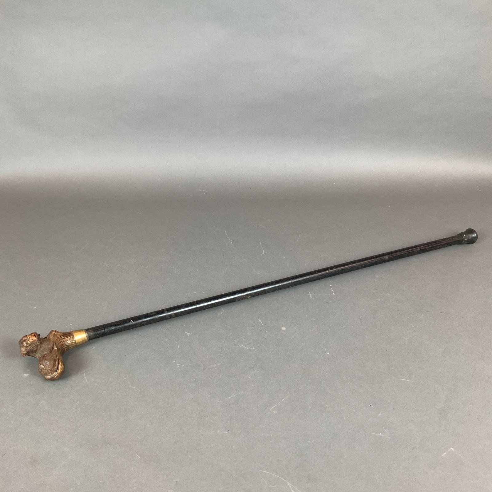 Wooden Walking Cane with Mechanical Dog Head: This carved wood gadget cane features a handle sculpted in the form of a seated pug. The handle incorporates a mechanical automaton feature where the dog mouth opens and the tongue sticks out when a b