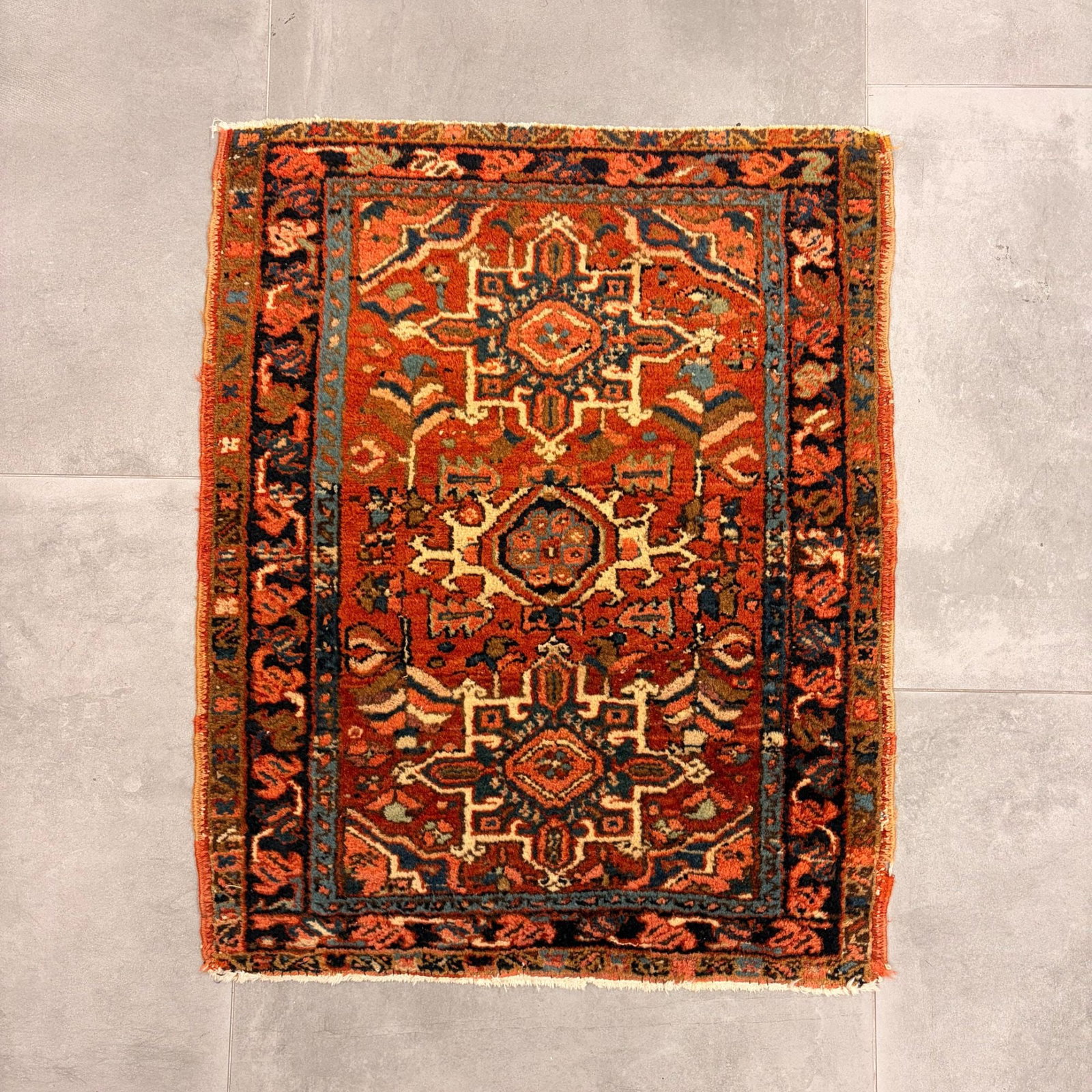 Antique Persian Karaja Hand-Knotted Village Rug with Triple Medallion Design: This hand-knotted Persian Karaja rug originates from the Azerbaijan province of Northwest Iran. It features a traditional triple-medallion layout set against a deep rust-red field. The design includes