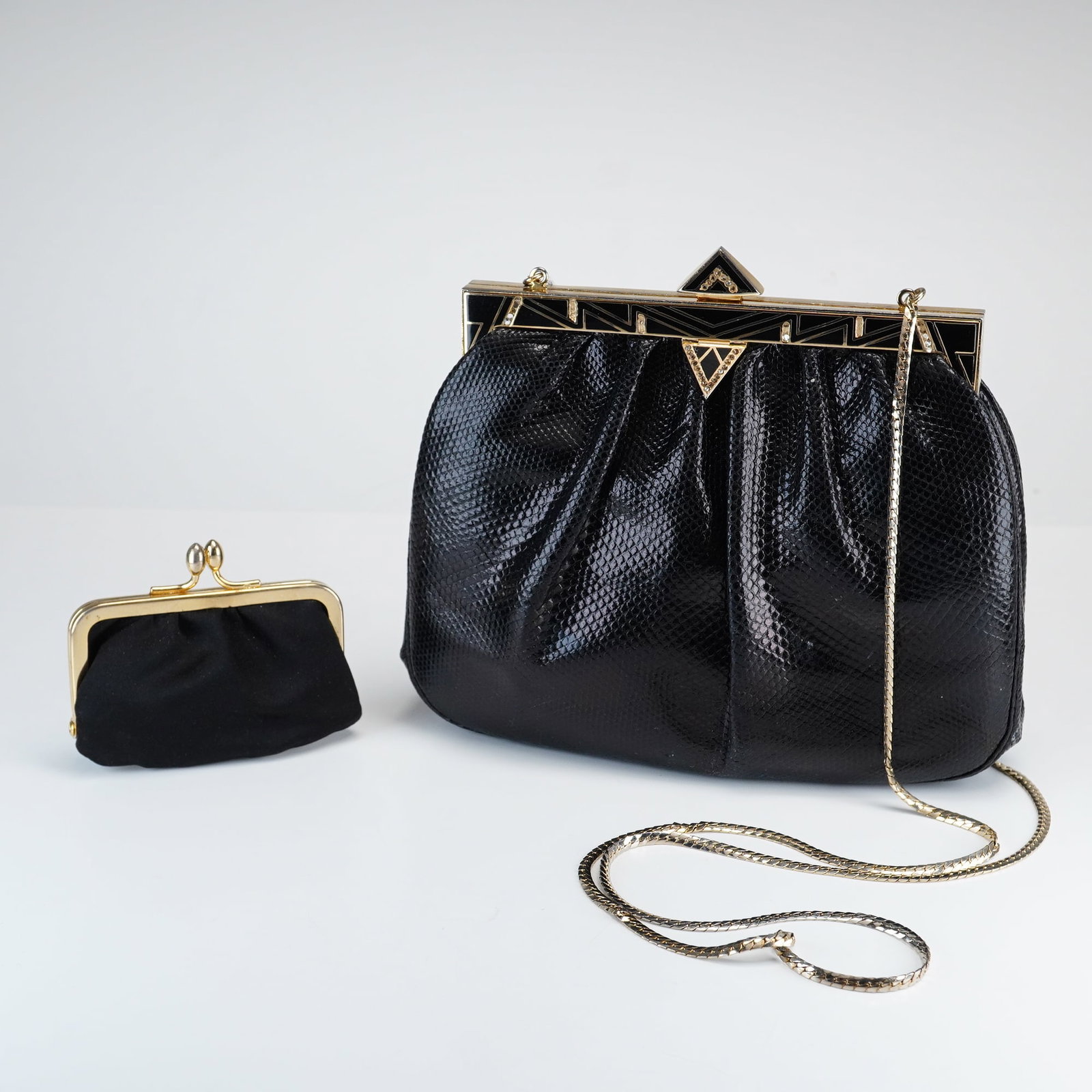 Vintage Judith Leiber Black Lizard Skin Evening Bag: Black lizard skin clutch with a gathered body and an Art Deco-inspired gold-tone metal frame featuring black geometric enamel inlays embellished with crystals and a tiered triangular clasp. The interi