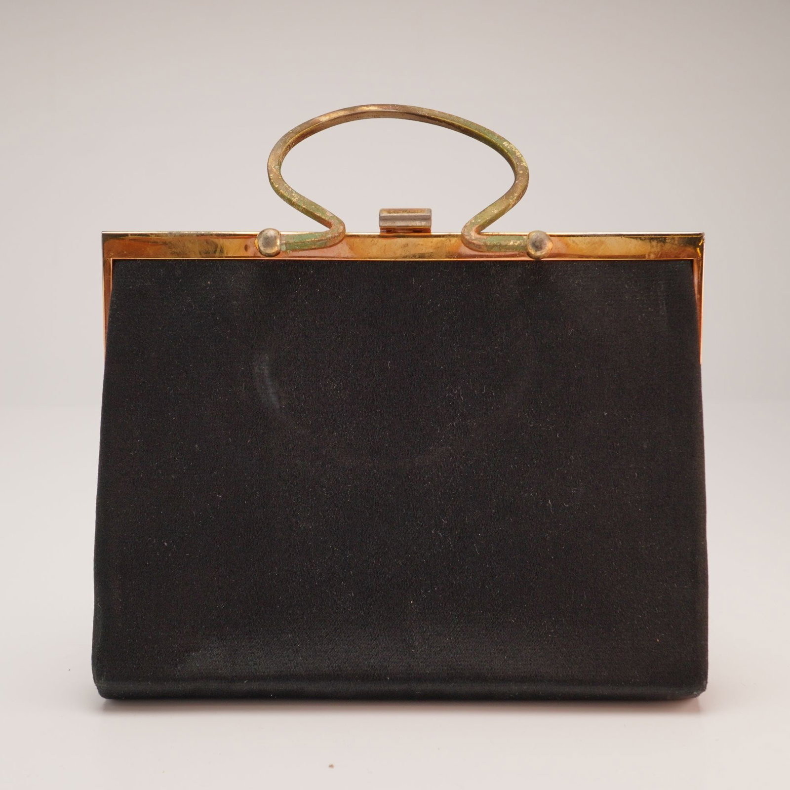 Loewe Vintage Black Velvet Top Handle Evening Bag: A vintage top-handle evening bag by the Spanish luxury brand Loewe. The exterior is fashioned from a black velvet fabric. The bag is constructed with a gold-tone metal frame and a rectangular