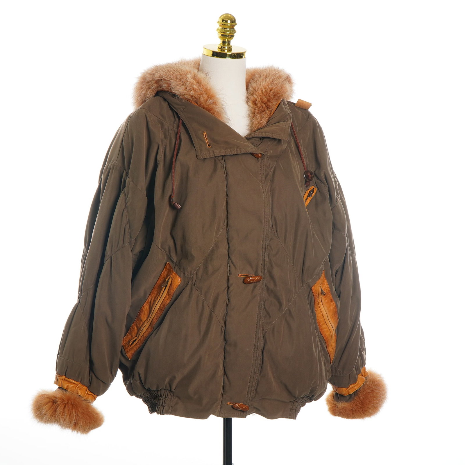 Green and Brown Quilted Parka with Fur Trim and Leather Accents: This vintage parka features an olive-brown shell with a diamond-quilted pattern. The garment is designed with a large hood and sleeve cuffs trimmed in thick, reddish-tan fur. Distinctive honey-colored