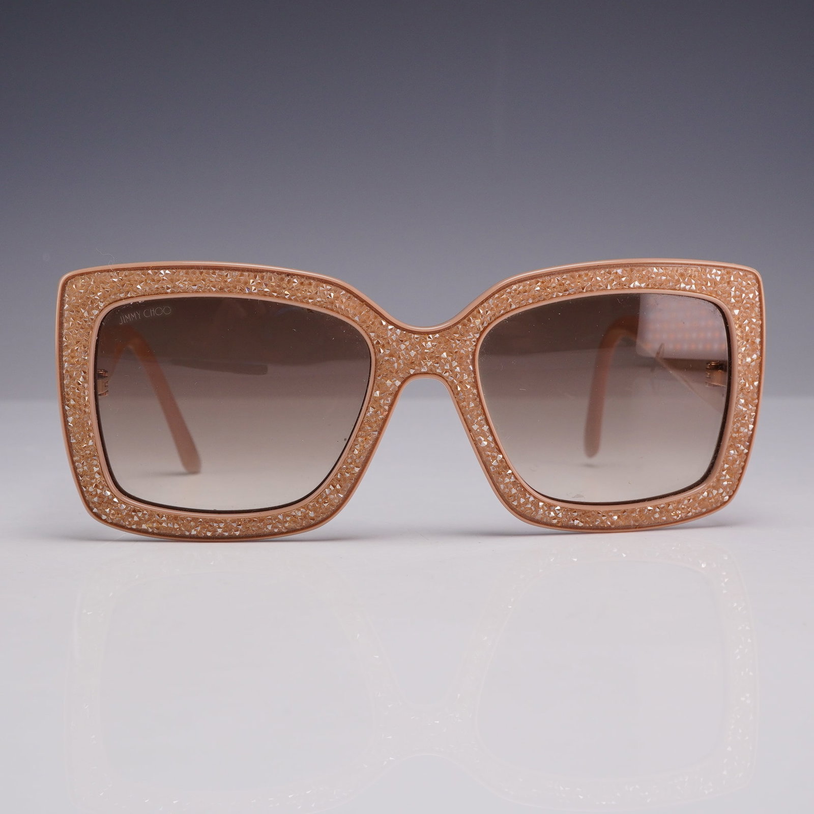 Jimmy Choo Viv Swarovski Crystal Square Frame Sunglasses: A pair of Jimmy Choo oversized square sunglasses, identified as the Viv model. The frames are constructed from nude-toned acetate, featuring a front face entirely embellished with tonal, faceted