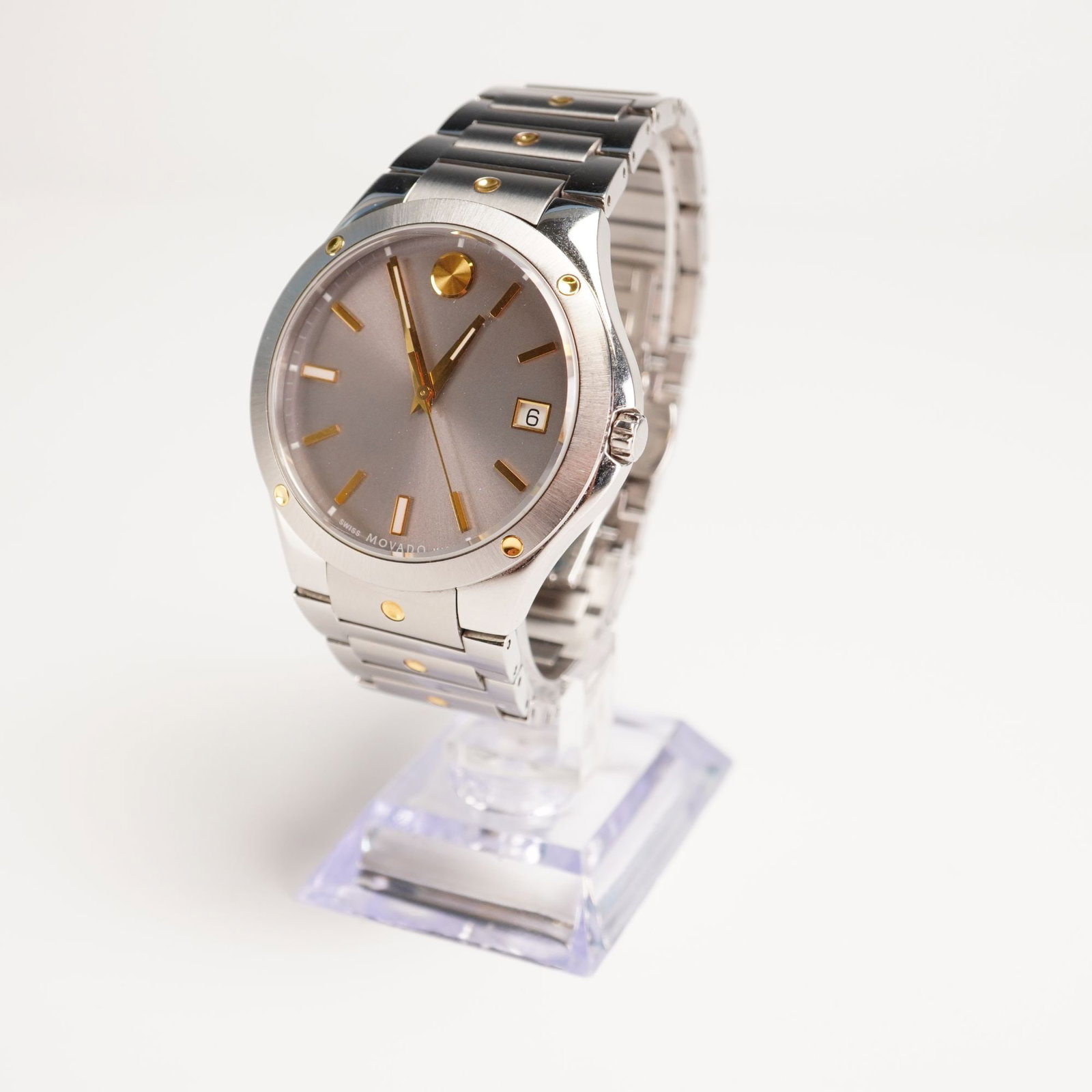 Movado SE Series Men's Stainless Steel Watch, Two-tone 0607514: Stainless steel silver watch face with gold accents set on two-tone link band; 41mm; water resistant 50m; sapphire crystal; Movado Swiss Made mark on reverse. Dimensions: 10"L Weight: 5.1 oz.