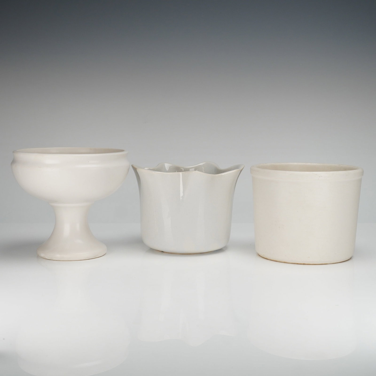 A Trio of McCoy Floraline White Ceramic Planters and Containers: A collection of three (3pc) white ceramic planters and storage containers from the McCoy Pottery Floraline design series. This group consists of three distinct forms, all finished in an off-white or c