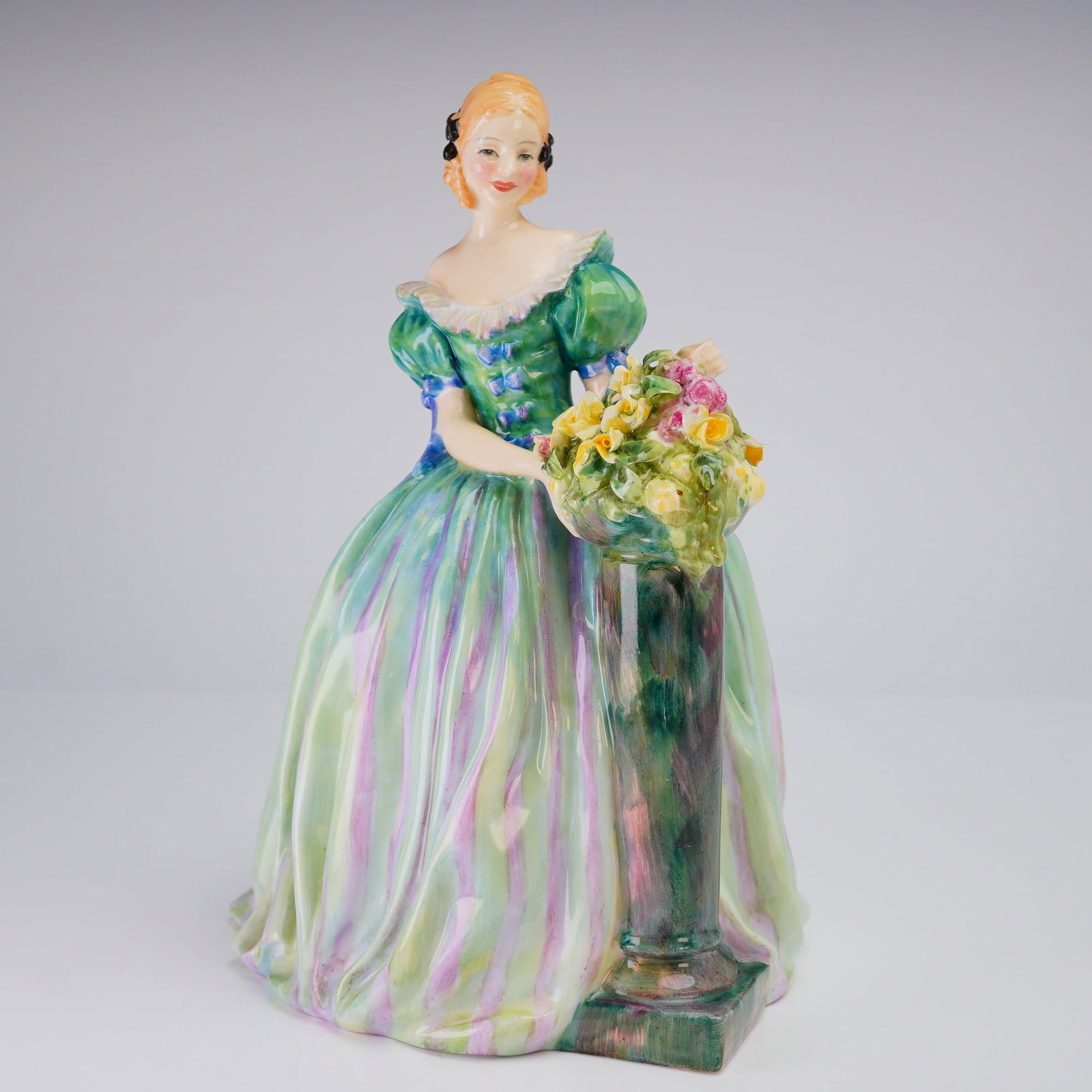Royal Doulton Bone China Figurine Roseanna HN1921: Royal Doulton Bone China Figurine, Roseanna (HN1921), depicting a woman in a striped green dress standing next to a pedestal of flowers, marked on the base with the title and model number. Dimensions: