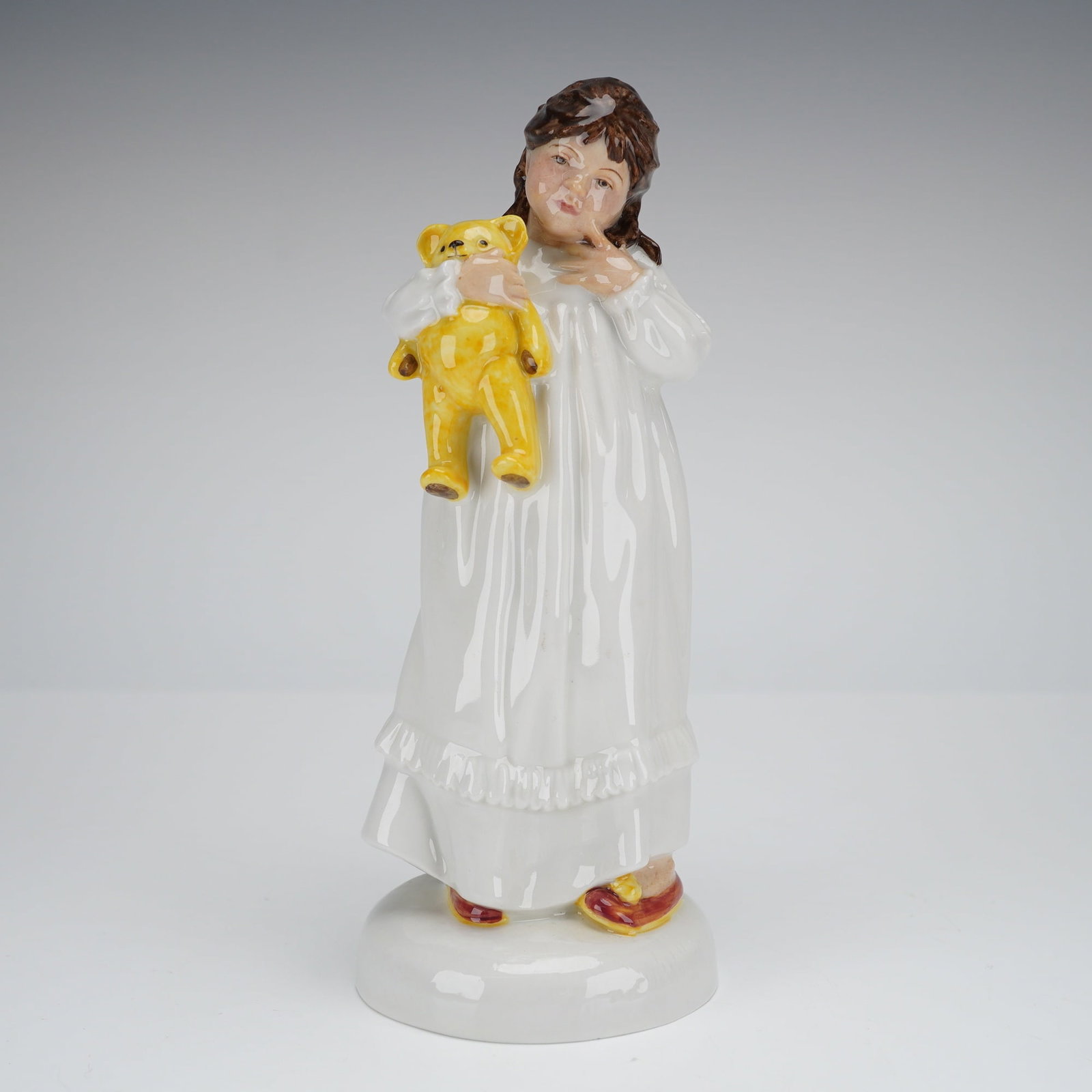 Royal Doulton Childhood Days And So To Bed Figurine HN2966: A single glazed bone china figurine by Royal Doulton, titled And So To Bed, model number H.N. 2966, belonging to the Childhood Days series. The figurine depicts a young girl standing in a long, white 