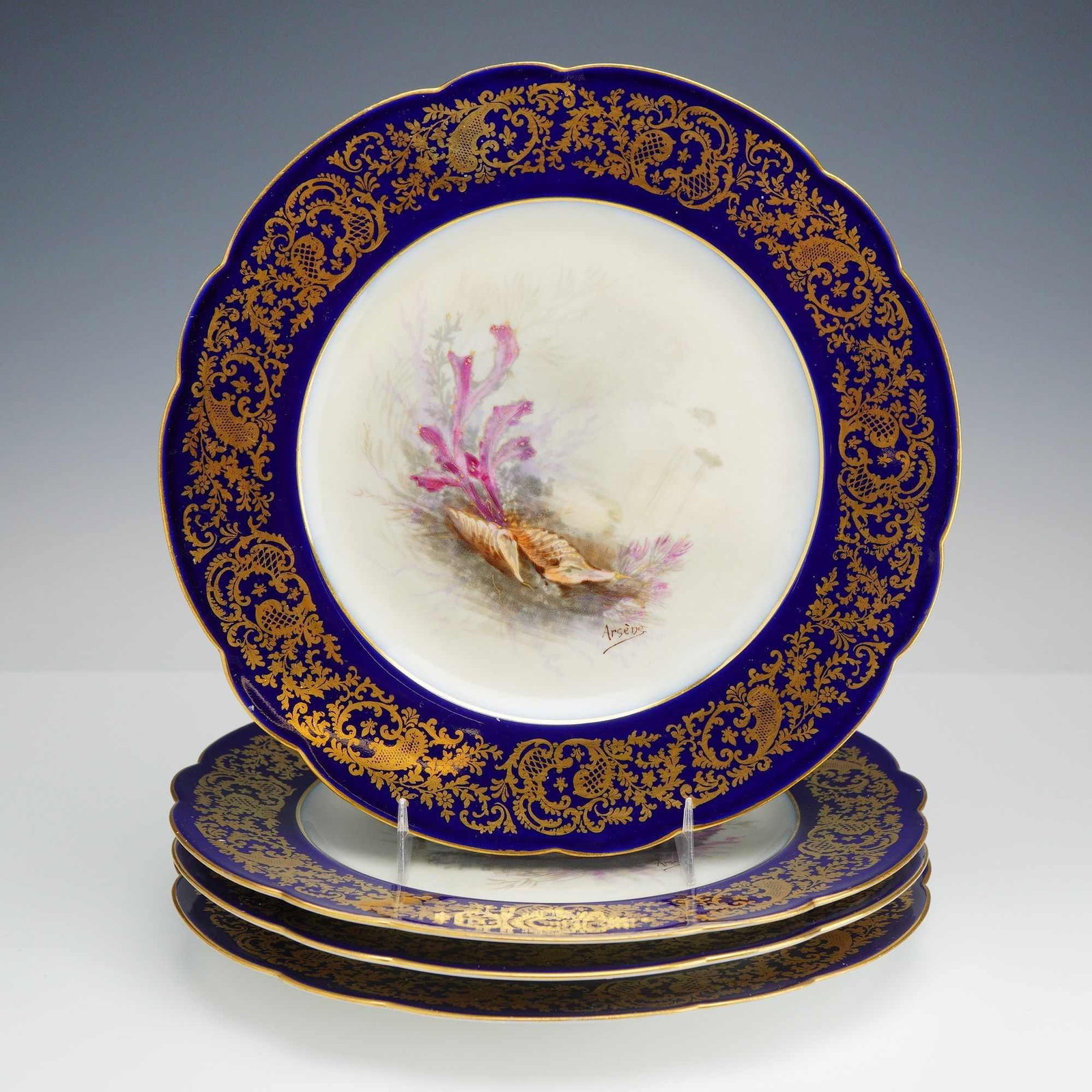 Set of 4 R. Delini?res and Cie Limoges Porcelain Cobalt Plates with Gilt and Seashell Theme: A set of four hard-paste porcelain plates produced by R. Delini?res and Compagnie in Limoges, France. Each plate features a distinct hand-painted central vignette depicting a seashell theme with vario