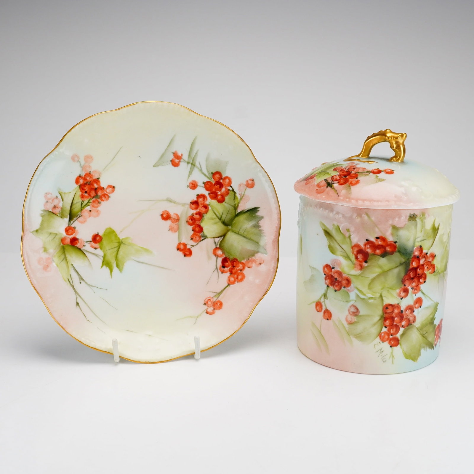 2pc Limoges Hand Painted Porcelain Jam Jar and Plate: This two-piece porcelain grouping includes a lidded jam jar and a matching small plate. The set is produced by A. Klingenberg and Dwenger (AKD) of Limoges, France, dating to the late 19th or early 20t
