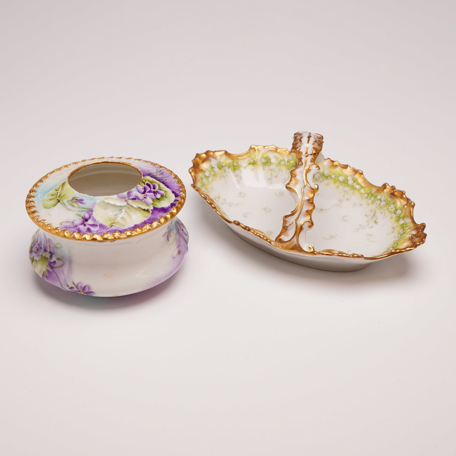 Two Porcelain Dish with Handle and Hair Receiver including Elite Limoges: The hair receiver features a squat, bulbous body and a separate domed lid with a central aperture. The exterior is decorated with a hand painted motif of purple violets and green foliage set against a