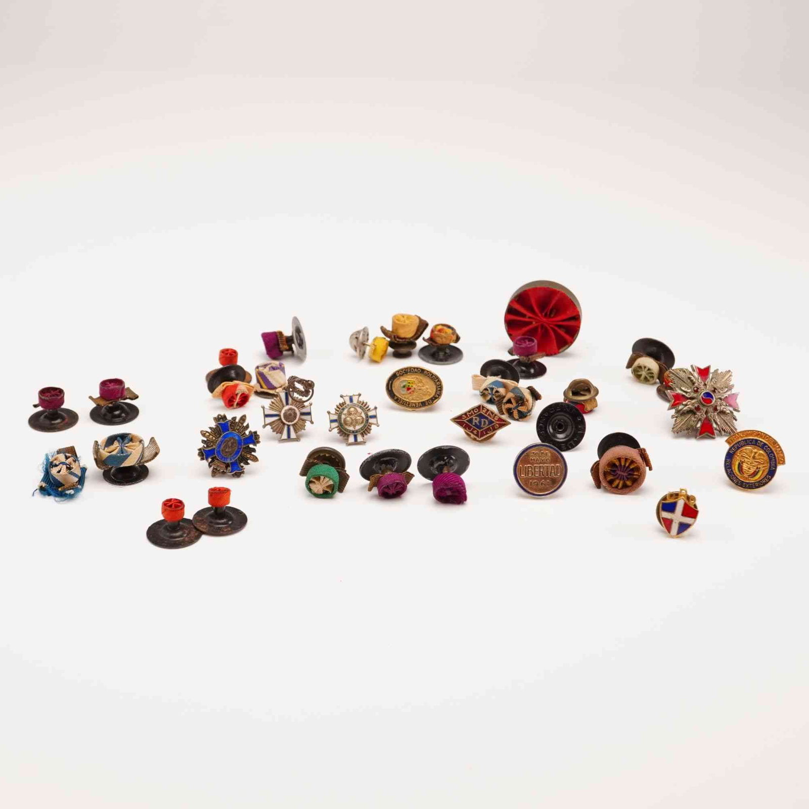 Collection of Vintage Pins and Leather Presentation Box: This grouping features a collection of vintage pins. The pins include various metal lapel pins and colorful ribbon rosettes in multiple patterns, reflecting a charming mix of styles and eras. Accompan