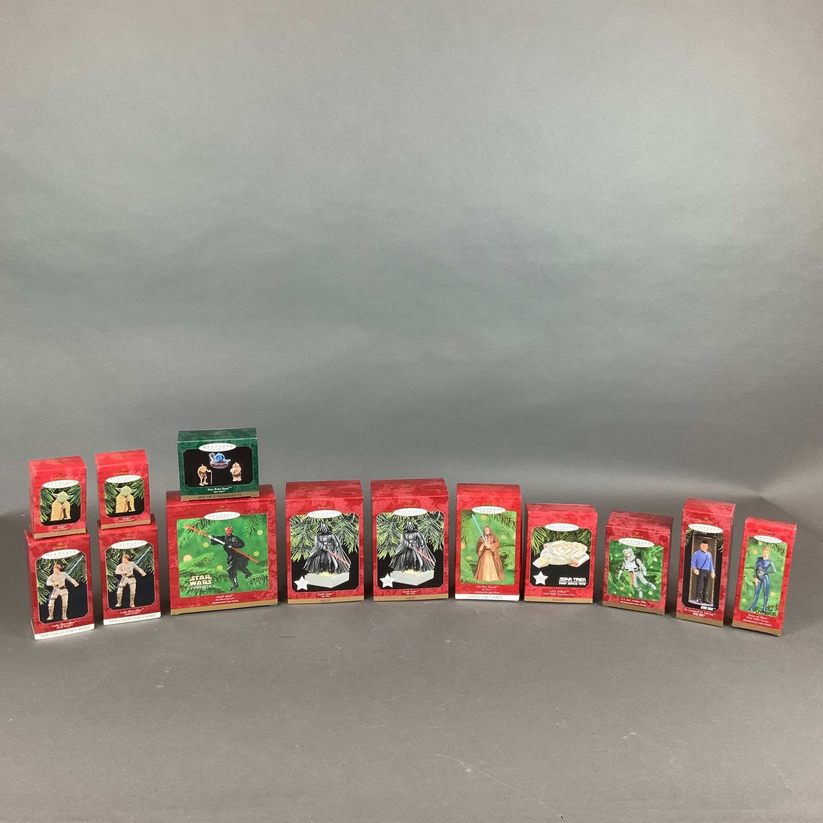 13pc Hallmark Keepsake Star Wars and Star Trek Holiday Ornament Collection: A collection of thirteen Hallmark Keepsake holiday ornaments, primarily featuring licensed characters and vehicles from the Star Wars and Star Trek franchises. The ornaments are manufactured from plas