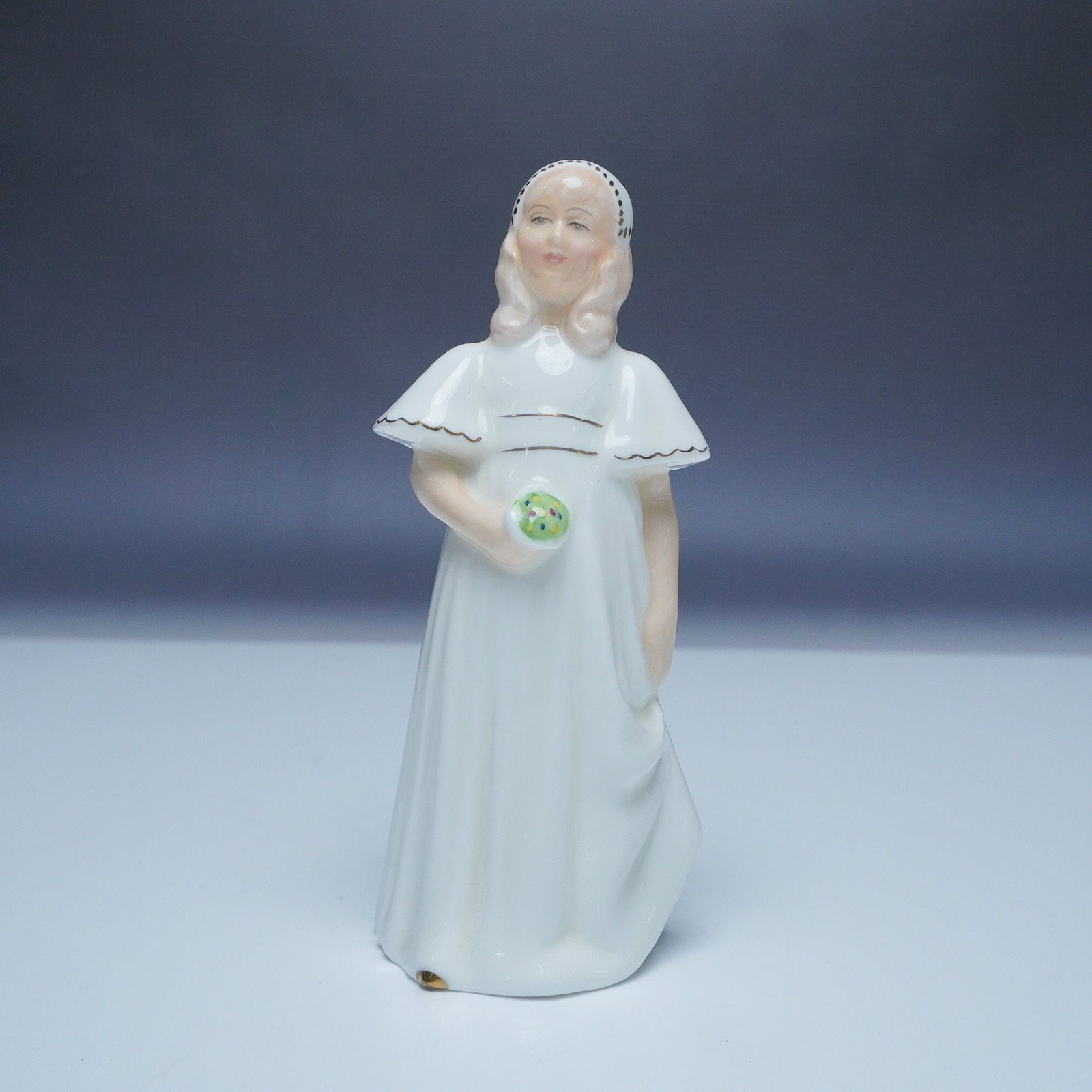 Royal Doulton Figurine, Bridesmaid HN 2874: Royal Doulton figurine Bridesmaid HN 2874, crafted from fine bone china. Designed by leading Royal Doulton artist and issued in 1979, this figurine features a young girl dressed in a flowing white bri