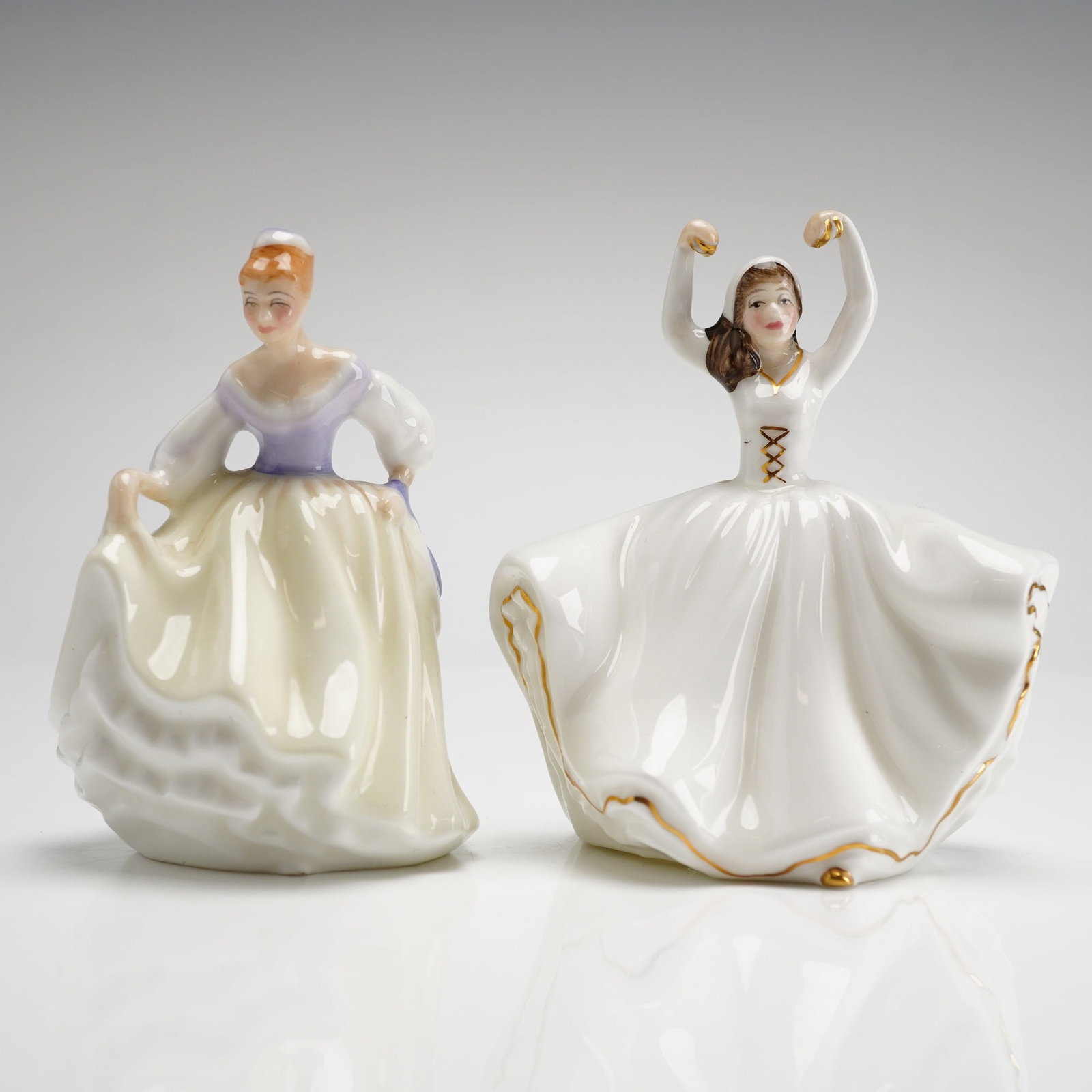 A Pair of Royal Doulton Mini Figurines Karen HN 3749 and Fair Lady HN 3216: This 2pc group of Royal Doulton mini figurines includes the models HN 3749 and HN 3216. The hand-decorated bone china pieces were designed by Peggy Davies and finished in a clear glaze. Fair Lady HN 3