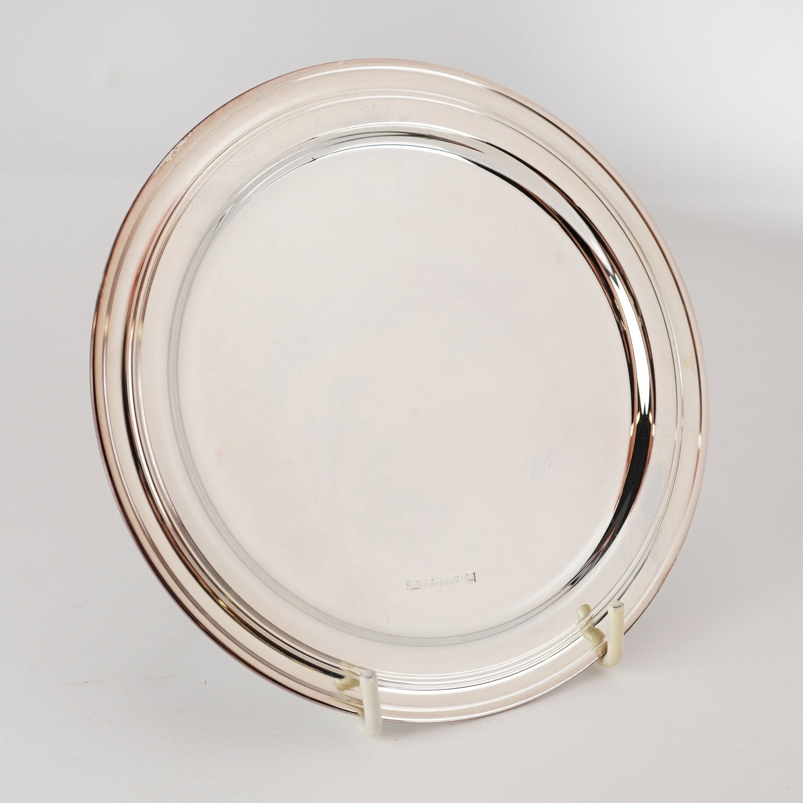 Christofle Albi Silver-Plated Round Platter: A French silver-plated circular serving platter in the Albi pattern by Christofle. The design is minimalist and modern, featuring a wide, flat rim and a shallow, recessed center. The entire surface is