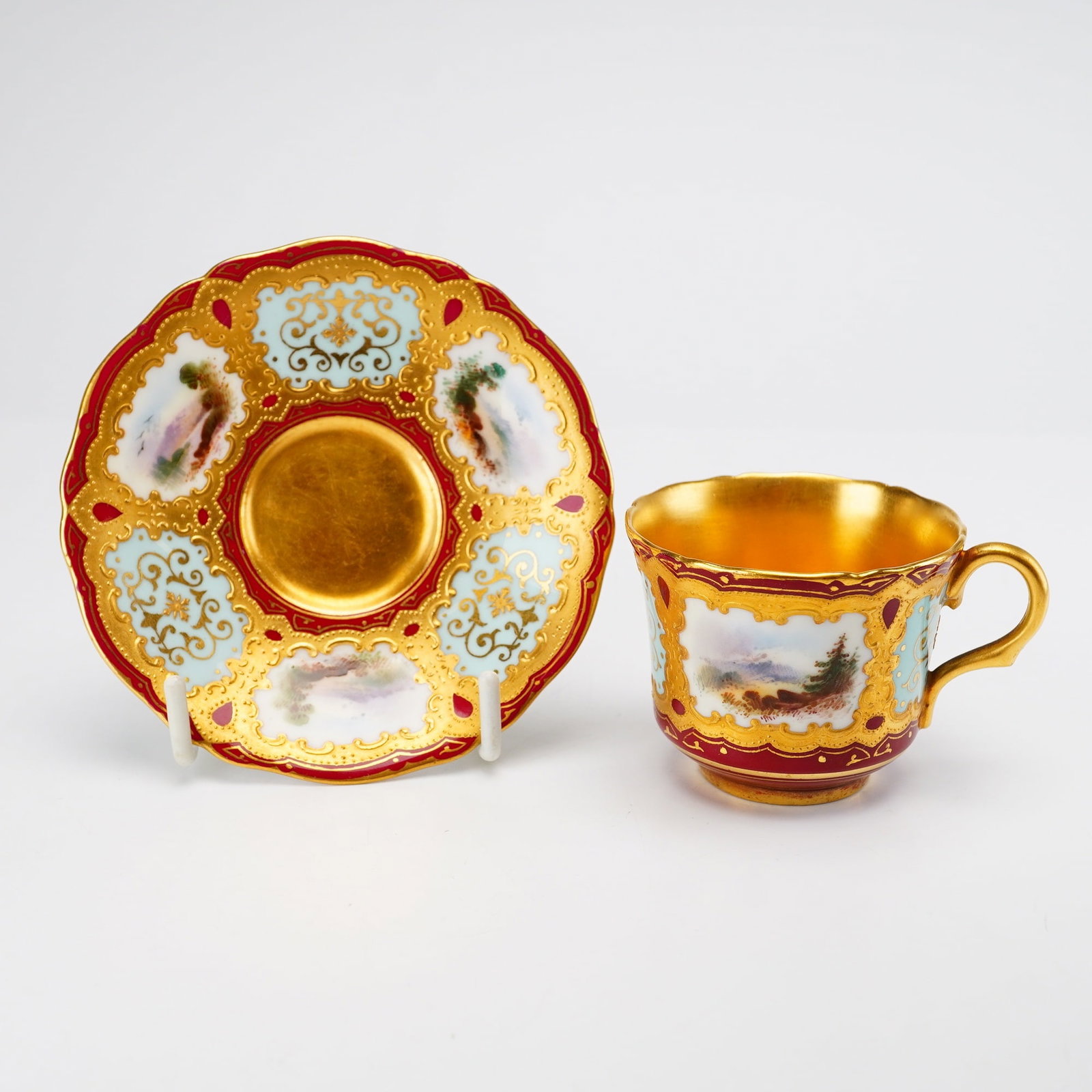 Coalport Porcelain Cup and Saucer Set for Richard Briggs Boston: This set consists of two pieces: a porcelain cup and matching saucer produced by Coalport in England for the retailer Richard Briggs of Boston. The set features a highly ornate design with alternating