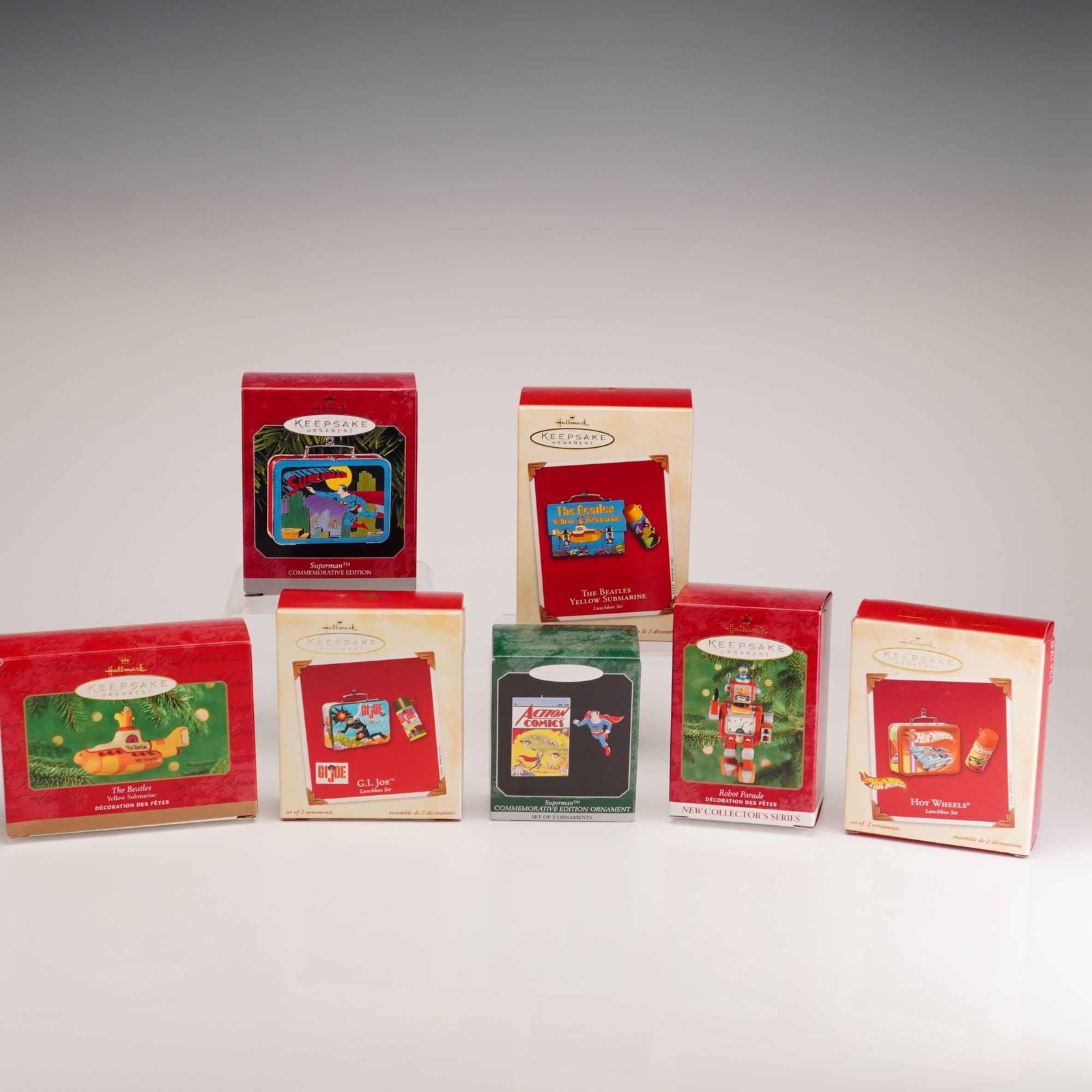 Seven Hallmark Keepsake Ornaments Featuring Cartoon Character Lunchbox Sets and Nostalgic Figures: This collection consists of seven Hallmark Keepsake Ornaments in their original retail packaging, featuring various cartoon character lunchboxes sets and nostalgic themes. The assortment includes