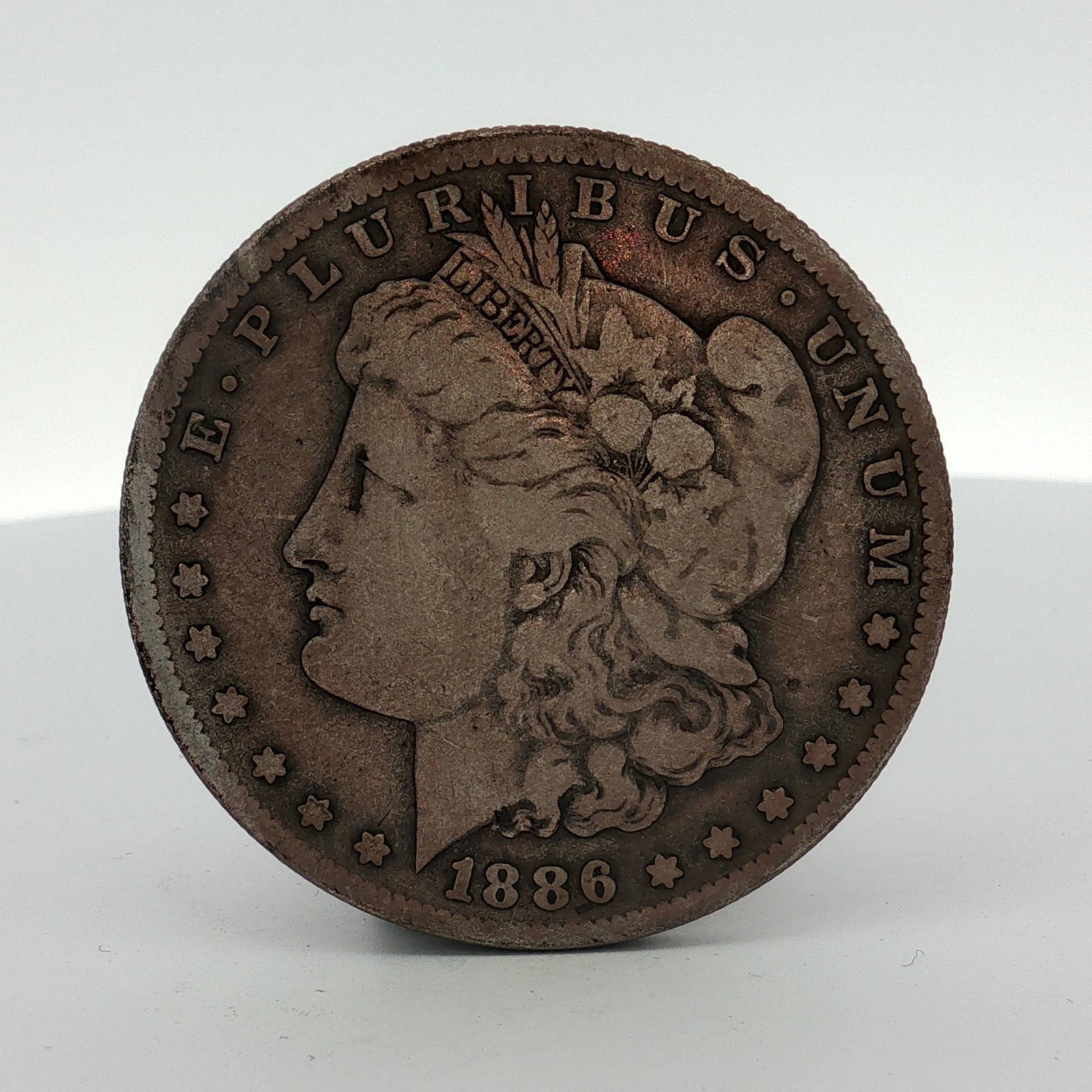 1886 US Morgan Silver Dollar: This 1886 United States Morgan silver dollar was struck at the San Francisco Mint. The coin is composed of 90 percent silver and 10 percent copper. The obverse features the Morgan Liberty head design 