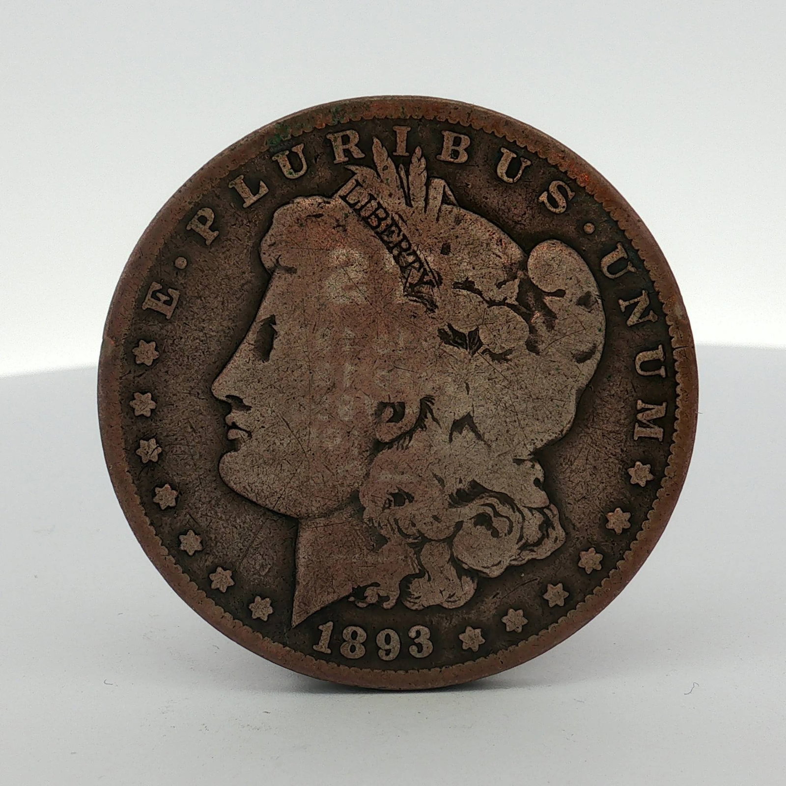 1893-O US Morgan Silver Dollar: This US Morgan silver dollar is dated 1893 and was struck at the New Orleans Mint, as identified by the "O" mint mark on the reverse. The coin features the Morgan Liberty obverse and the heraldic eagl