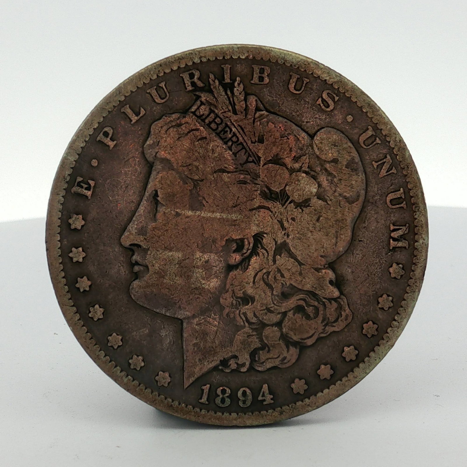 1894-S US Morgan Silver Dollar: This US 1894-S Morgan silver dollar is a struck coinage issue from the San Francisco Mint. The piece features the Morgan dollar obverse and eagle reverse designs. It is composed of 90% silver and 10% 