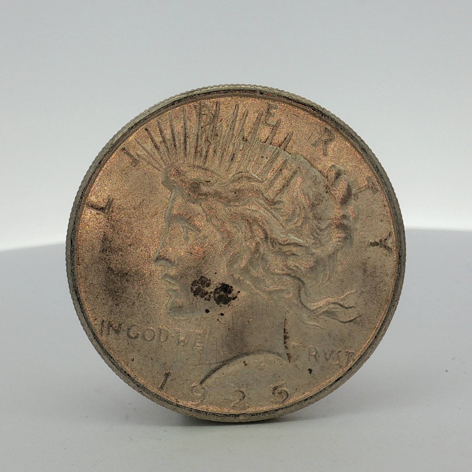 1925-S US One Dollar Peace Silver Dollar Coin, Circulated: This US 1925-S Peace silver dollar was struck at the San Francisco Mint. The coin is composed of 90 percent silver and 10 percent copper. The obverse features the standard Peace dollar design with the