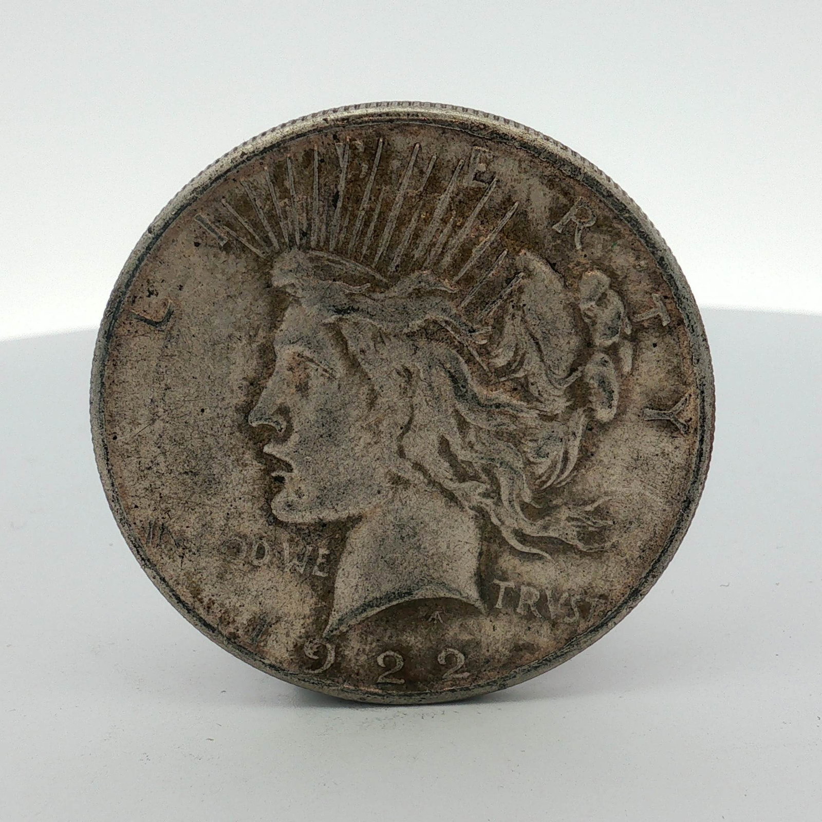 1922 US Peace Silver Dollar: A 1922 United States Peace silver dollar, struck at the Philadelphia Mint. This specimen is composed of 90% silver and 10% copper, weighing approximately 26.73 grams with a diameter of 38.1 mm. The ob