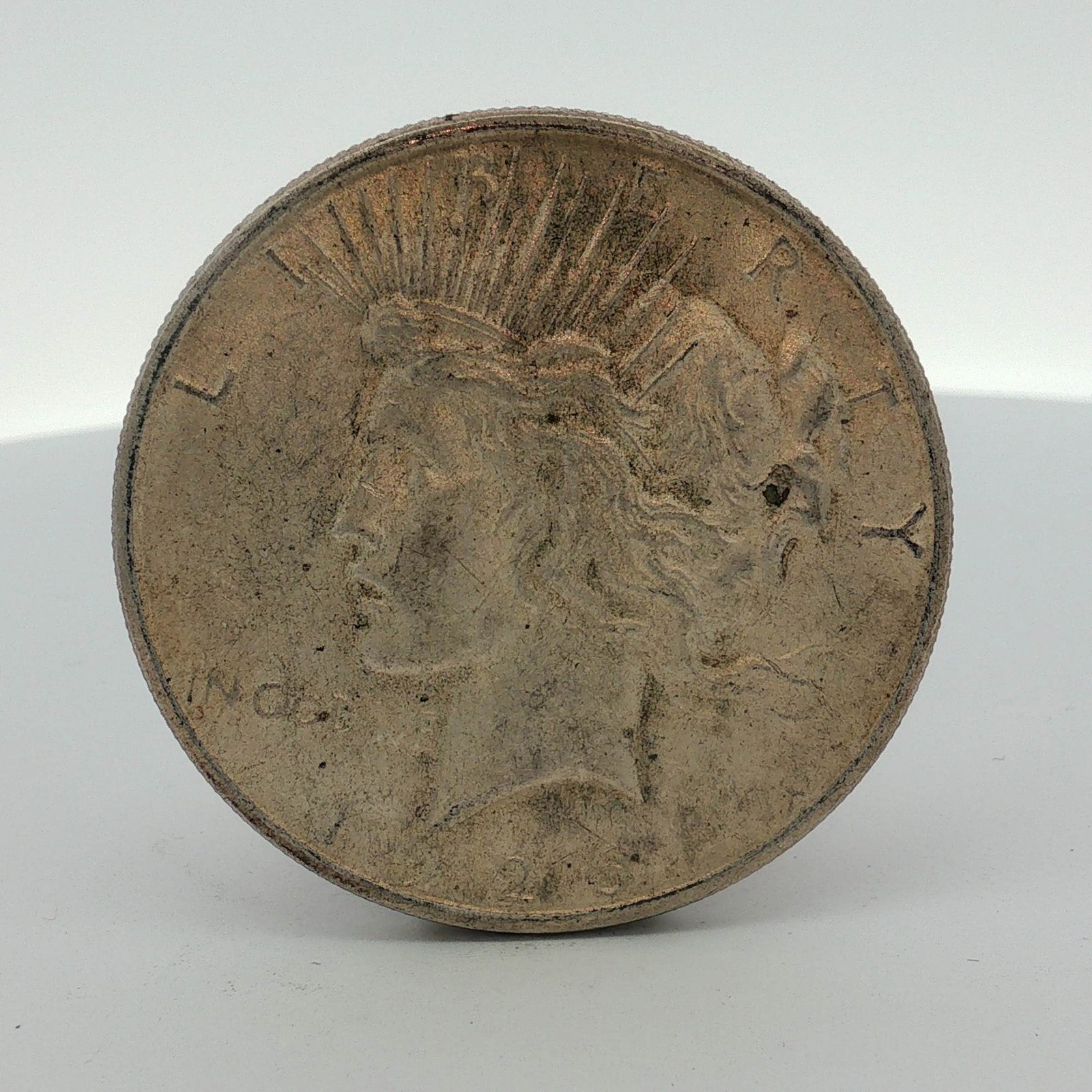 1923 US Peace Silver Dollar: This 1923 US Peace silver dollar is struck in 90 percent silver and 10 percent copper. The obverse displays the date 1923 along with the inscriptions LIBERTY and IN GOD WE TRVST. The reverse features 