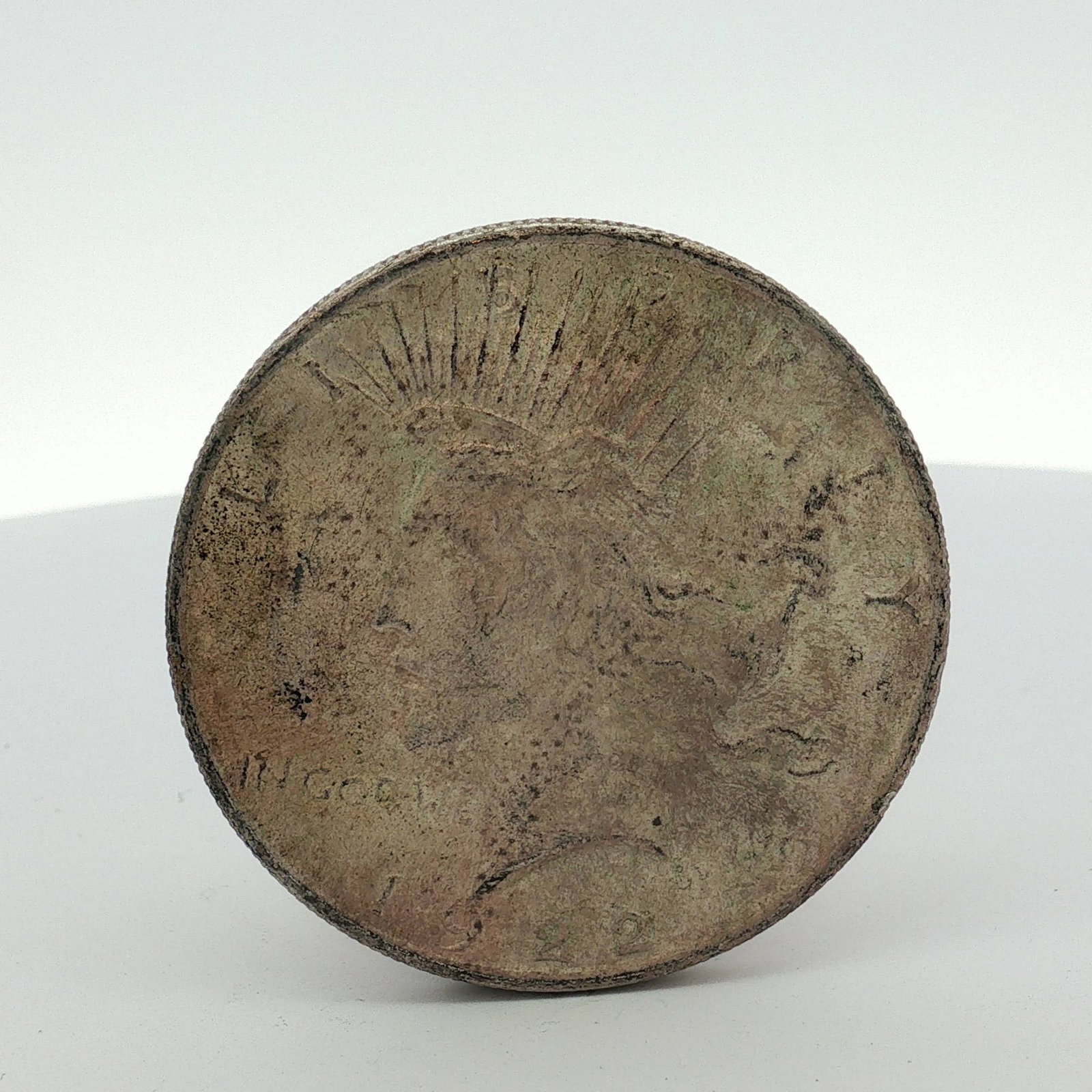 US 1922 Peace Silver Dollar: This US 1922 Peace silver dollar was struck at the Philadelphia Mint. The coin features a silver composition and a reeded edge. The obverse displays the date 1922 and the motto IN GOD WE TRVST. The