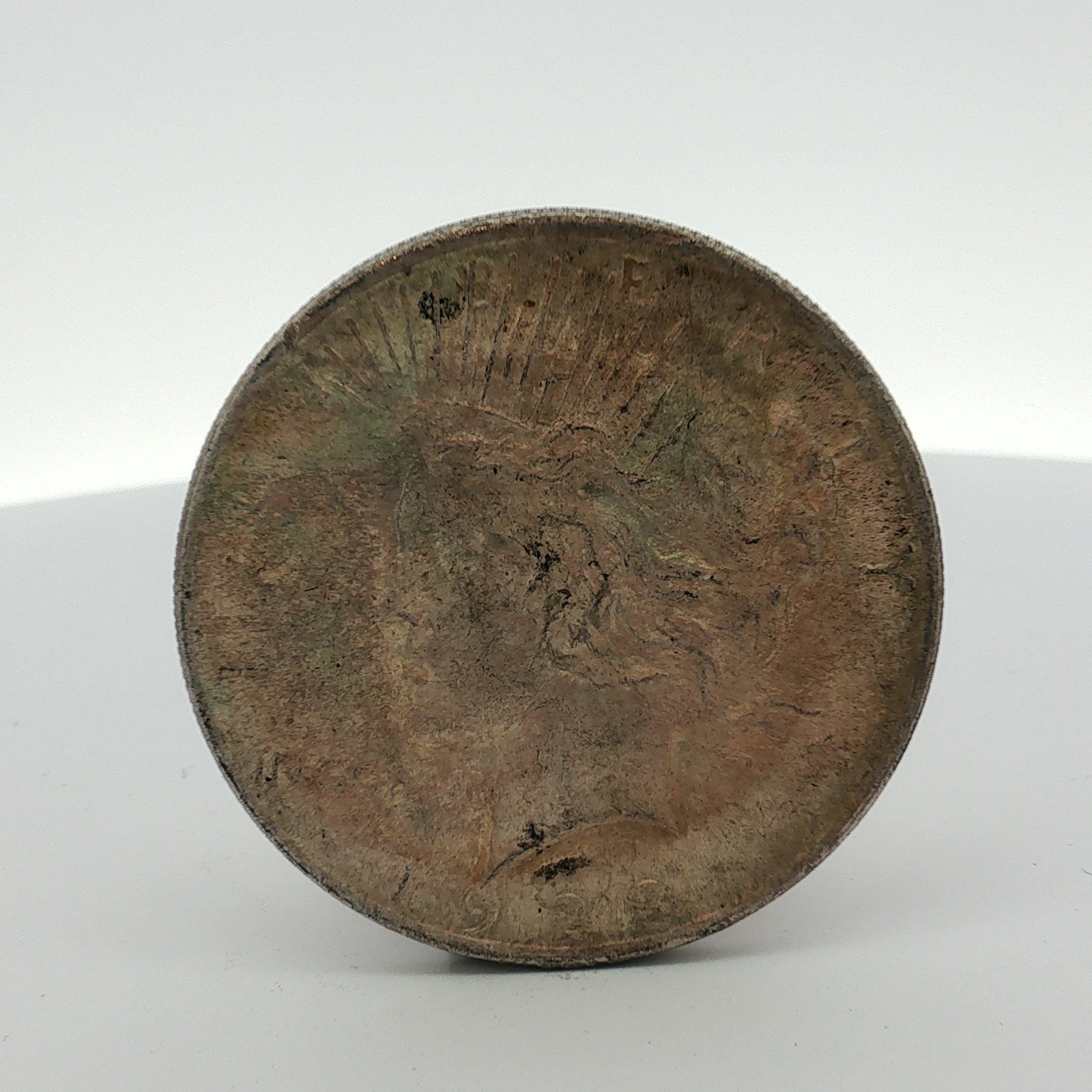 US 1923 Peace Silver Dollar: This US silver coin is a Peace dollar struck in 90% silver. The obverse features the Peace dollar type with the date 1923 faintly visible at the base. The reverse displays the standard Peace dollar re