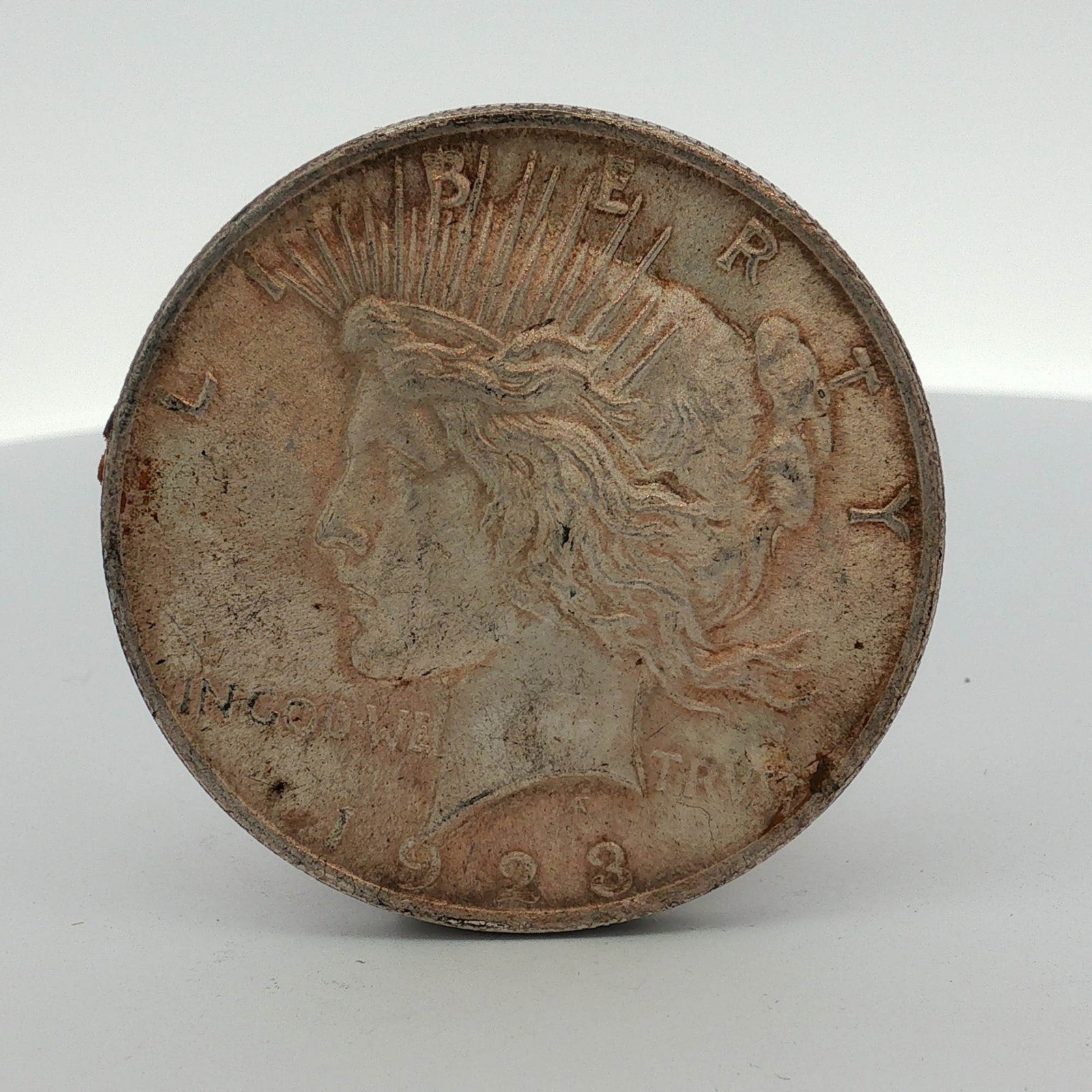 US 1923 Peace Silver Dollar: This US 1923 Peace silver dollar is a business strike specimen from the Philadelphia Mint. The obverse features the Liberty design and the reverse displays the Peace eagle design, both by Anthony de