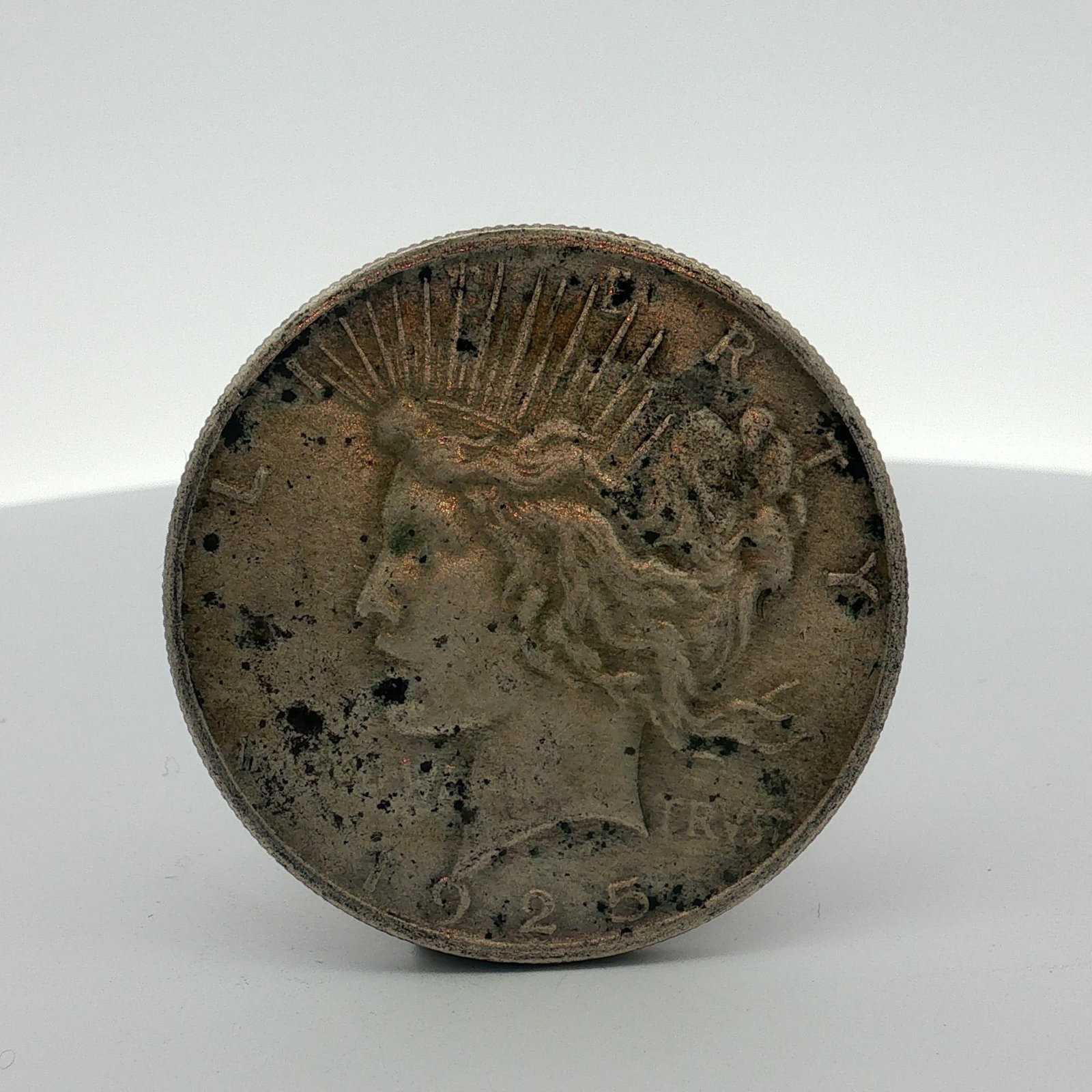 US 1925 Peace Silver Dollar: US 1925 Peace silver dollar. This Philadelphia mint issue contains no mint mark. The coin is composed of 90 percent silver and 10 percent copper. Design type is the Peace dollar, which was issued