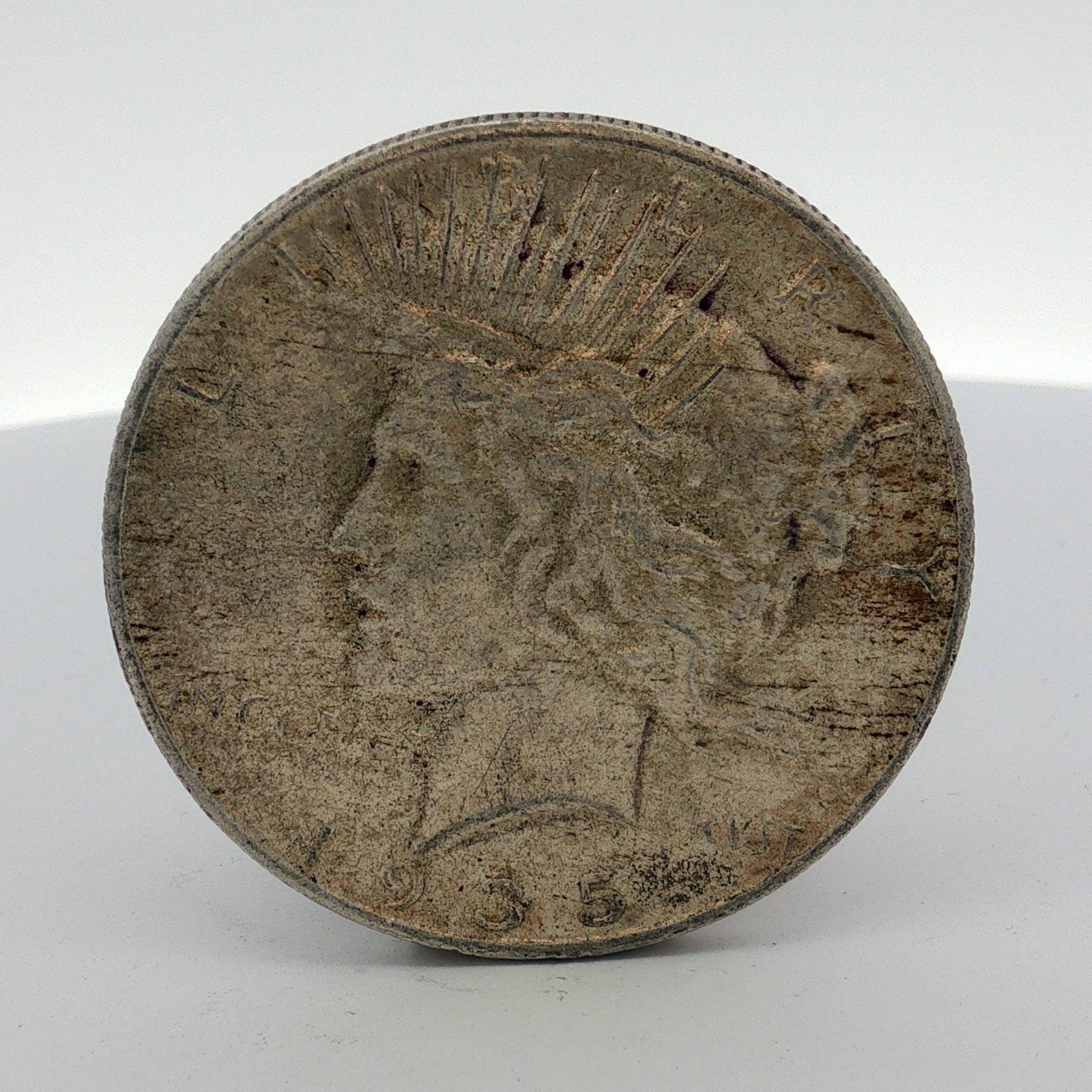 US 1935 Peace Silver Dollar: This US 1935 Peace silver dollar is composed of 90% silver. The 1935 issue represents the final year of production for the Peace dollar series. The obverse features the Peace Dollar obverse design