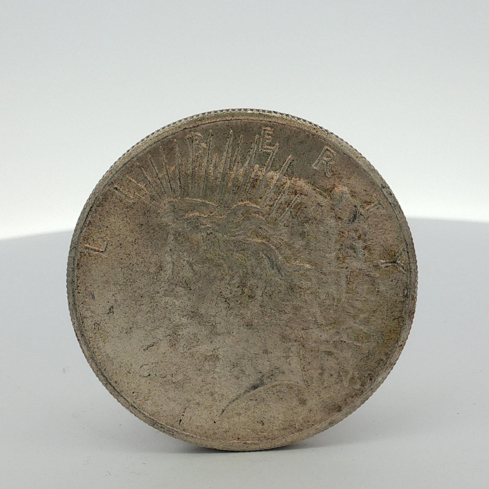 US Peace Silver Dollar: US Peace silver dollar. Metal composition: 90 percent silver, 10 percent copper. This coin features the standard Peace dollar obverse and reverse designs. Obverse inscriptions include partial characte
