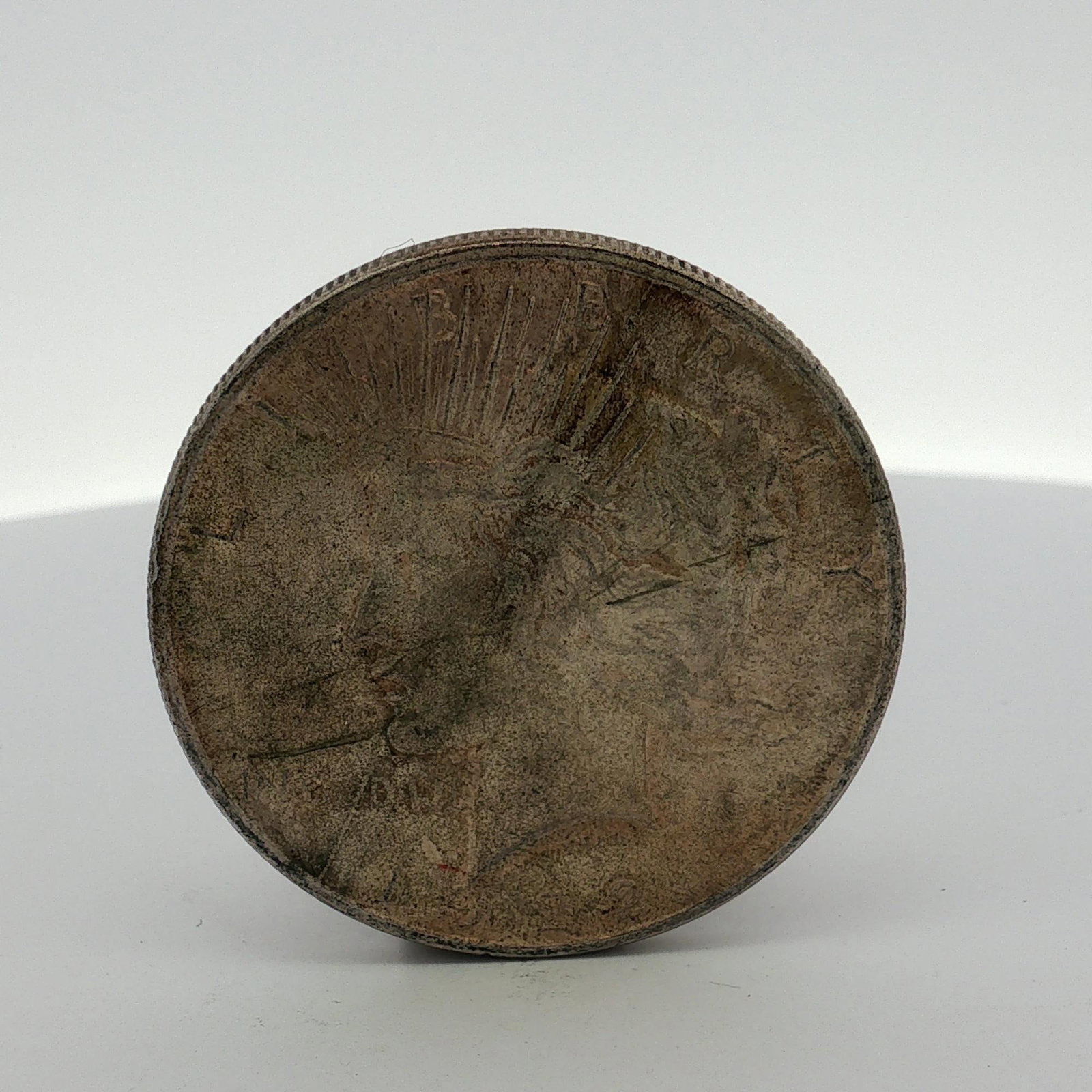 US Silver Peace Dollar, Circa 1920s: This US Peace dollar is composed of 90 percent silver and 10 percent copper. The obverse features the Liberty head design with a radiate crown and the partial date 192[?] visible at the base. The
