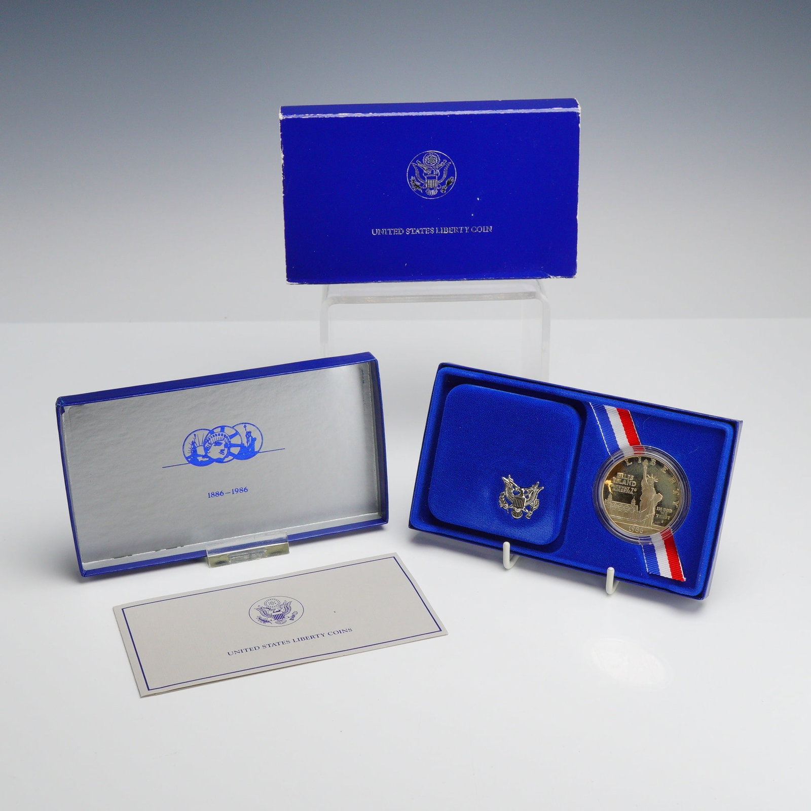 1986-S US Liberty Silver Dollar Ellis Island Centennial Commemorative Proof: 1986-S US Liberty silver coin, specifically the Ellis Island Centennial Commemorative Silver Dollar. This proof strike coin is composed of 90 percent silver and 10 percent copper. The obverse bears