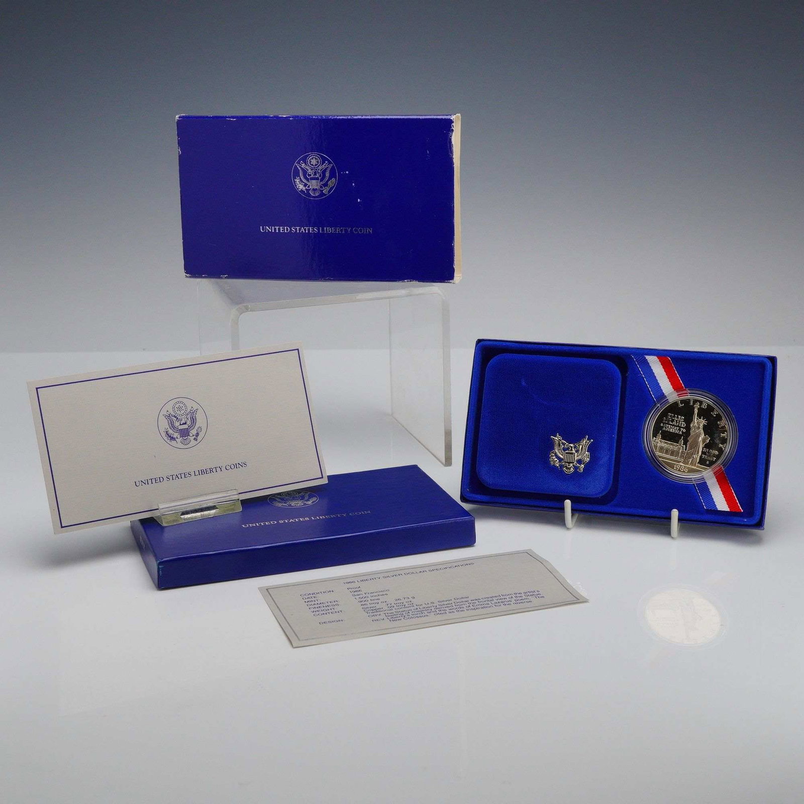 1986-S US Liberty Silver Dollar Proof Coin Set in OGP: A 1986-S US Liberty silver dollar commemorative coin struck in .900 fine silver. This proof specimen features frosted relief on mirrored fields and was produced at the San Francisco Mint, as