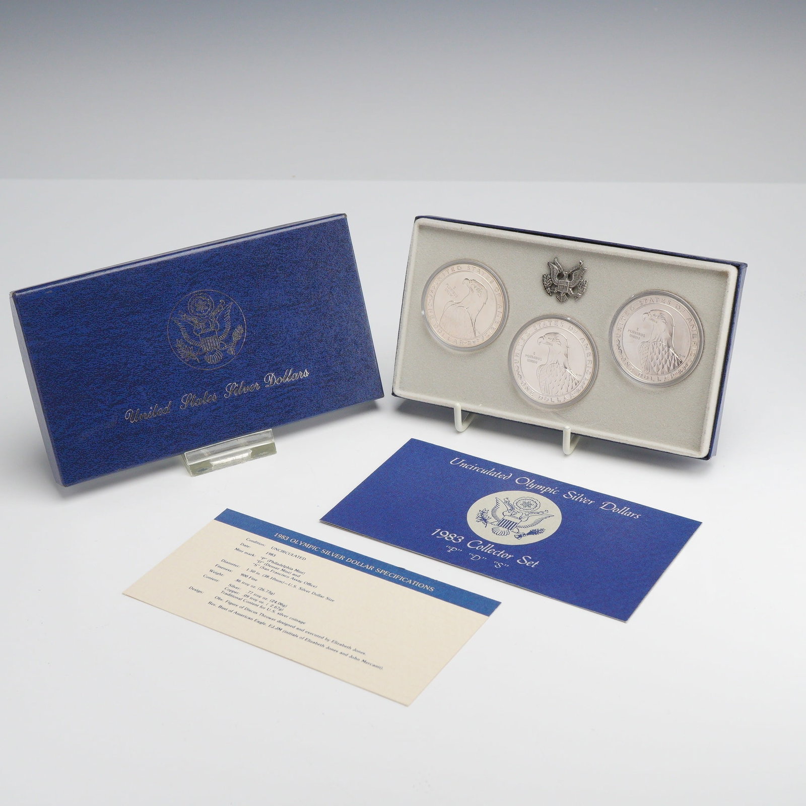 Three 1983 US Olympic Silver Dollars P, D, and S Uncirculated Set in Box: This set of three US silver dollars was issued by the US Mint to commemorate the XXIII Olympiad in Los Angeles. The collection contains uncirculated specimens from the Philadelphia (P), Denver (D), an