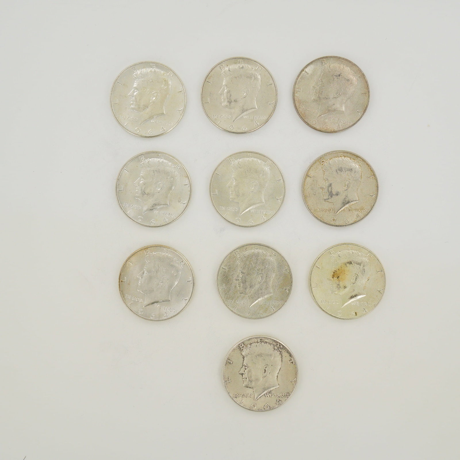 A Collection of US 1964 Kennedy Half Dollars $5.00 Face Value: This collection of US Kennedy half dollars is dated 1964 and represents a $5.00 face value. Each coin is struck in 90% silver. These specimens were produced at the Philadelphia Mint and feature the Ke
